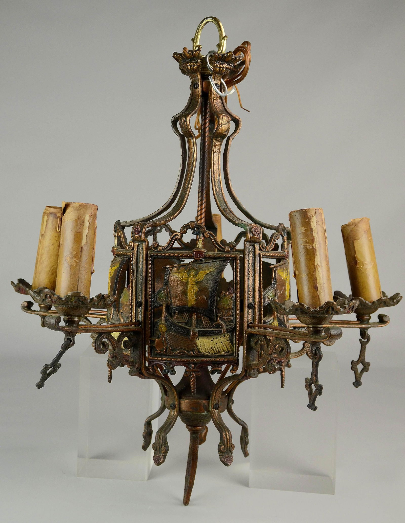 Heavy Chandelier with Ship Panels: Heavy bronze patinated iron chandelier, five panels depicting sailing ships with angels on the sail, each panel marked "Pat'd", five arms with candle sleeves, missing two drops, 20-1/2" h
