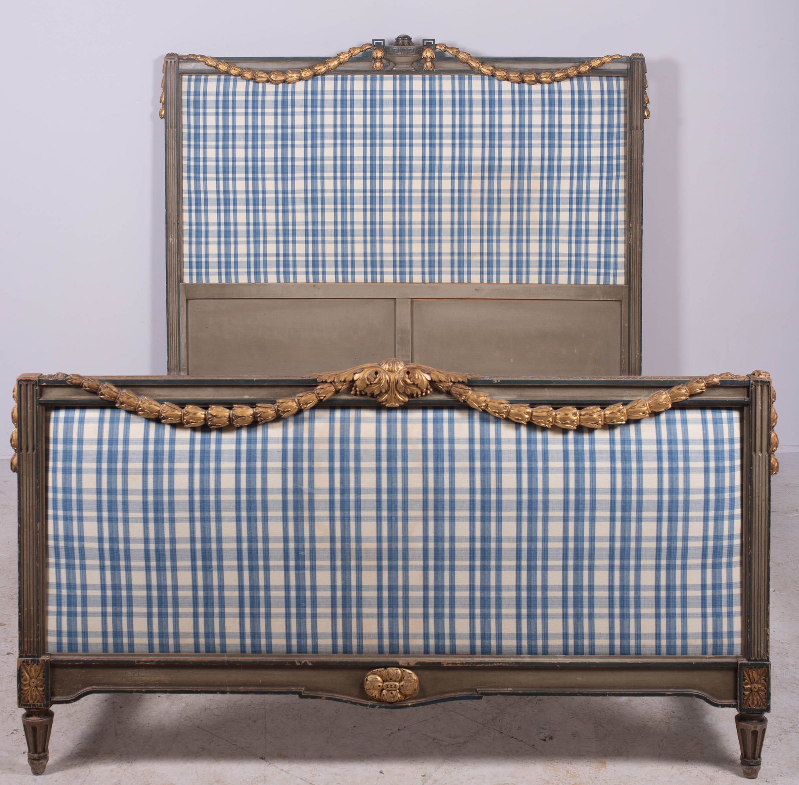 French style carved & painted full size bed: French style carved & painted full size bed, green painted frame with gilt painted swag draped off an urn, blue checkered upholstered insert in headboard and footboard, headboard 52" h x 60" w