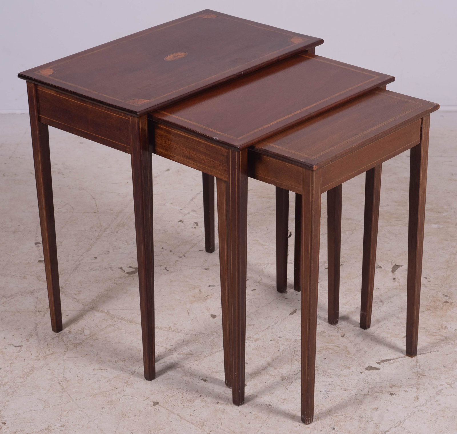 Mahogany set of 3 inlaid nesting tables: Mahogany set of 3 inlaid nesting tables, top with inlaid fan decoration, string inlaid legs and sides, largest table 23-1/2" h x 22" w x 13-1/2" d