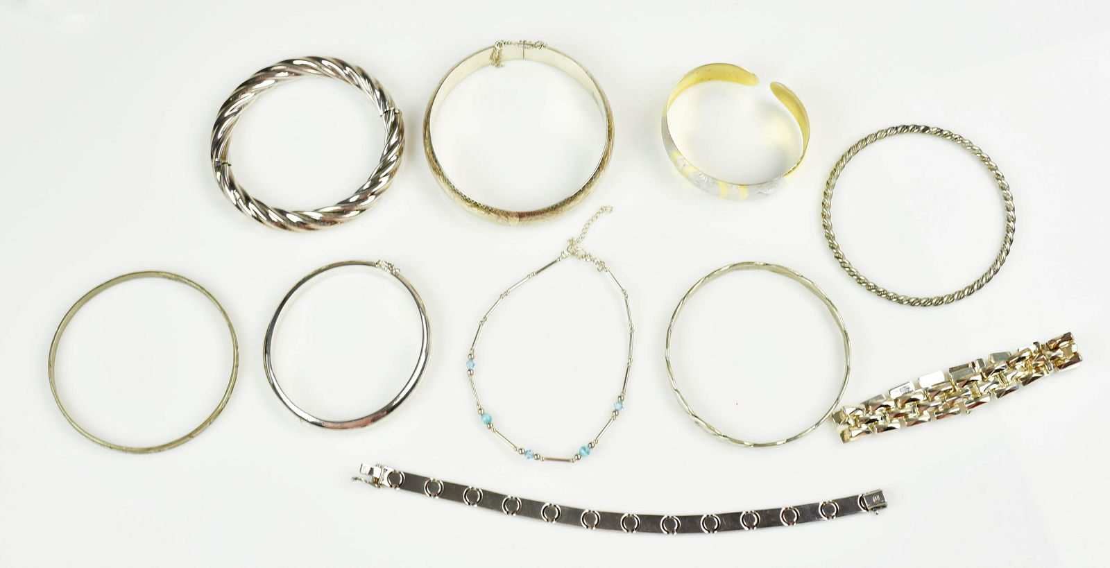 (10) Pc Lot of Silver and Sterling Bracelets: (10) Silver Bracelet Lot C/O; (3) open and close bangles, (1) Silver with gold overlay cuff bangle, (3) solid banges, (2) loose link bracelets and (1) beaded bracelet , 103.6 Dwt. (5.6oz)
