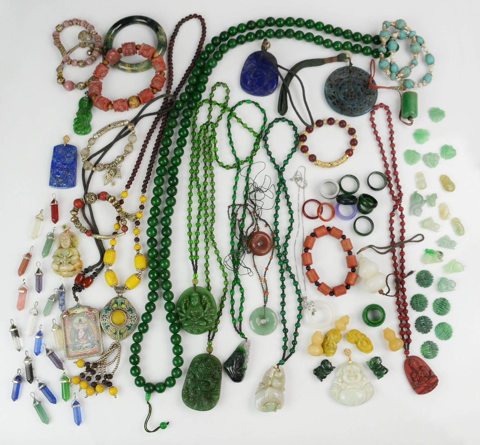 A collection of Stone Carved Jewelry: A Collection of Semi-Precious Carved Lapis, Jade , Aventurine, Quartz Gemstone Costume Jewelry C/O; (8) bracelets, (29) small jade asian carvings, approximately 19 quartz pendants, 13 stone rings (ban