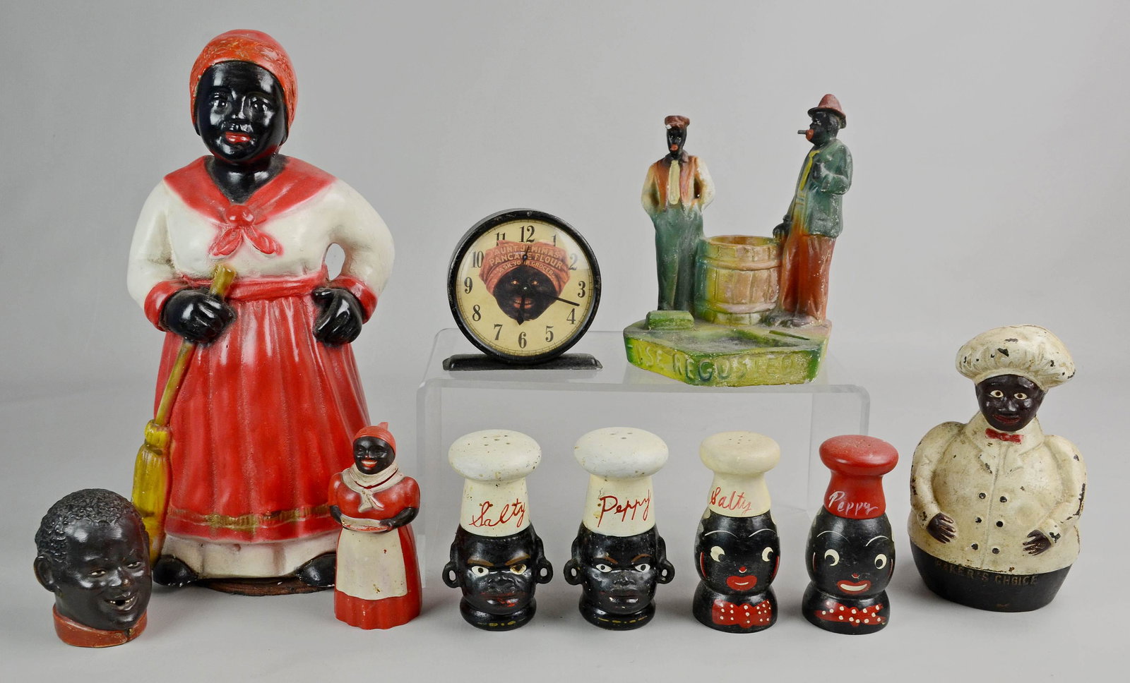 Black Americana Grouping: Black Americana grouping c/o (2) figural salt and pepper shakers, cast iron Bakers Choice bank, (1) Aunt Jemima clock, (1) syrup dispenser, (1) figural cigarette holder and (2) pcs figural chalkware, 