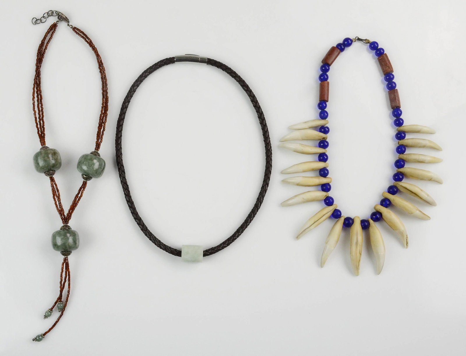 (3) Asian Necklaces: (3) Asian necklaces, c/o green stone with amber seed beads, green stone on braided leather cord, animal teeth with blue glass & stone beads