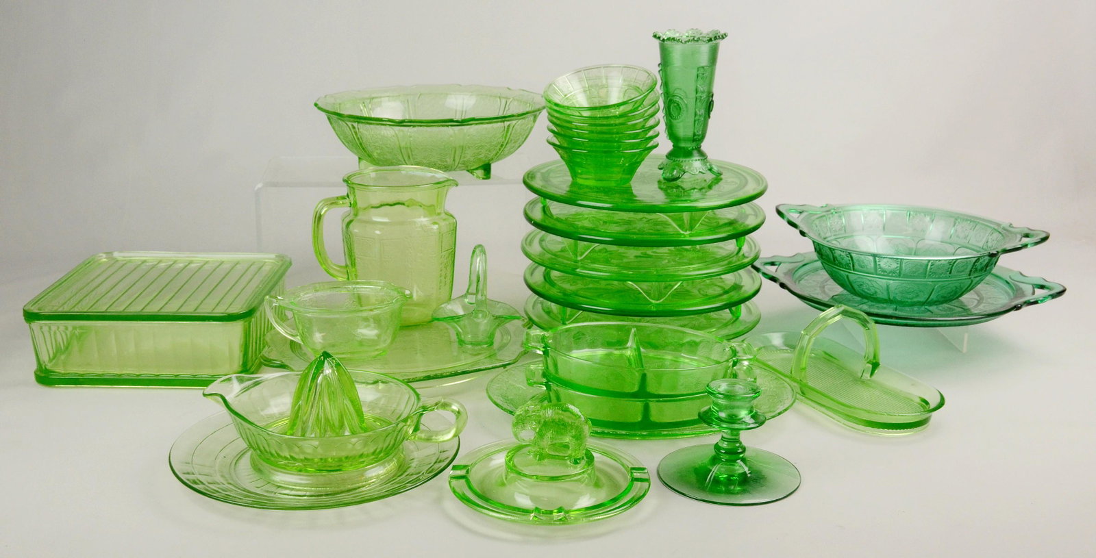 Large Green Depression Glass Grouping: Large green depression glass grouping c/o green glass pitcher, (6) berry bowls, juicer, figural animal topped ashtray, creamer, serving plate, (6) footed cake stands, (2) divided dishes, (1) handled d
