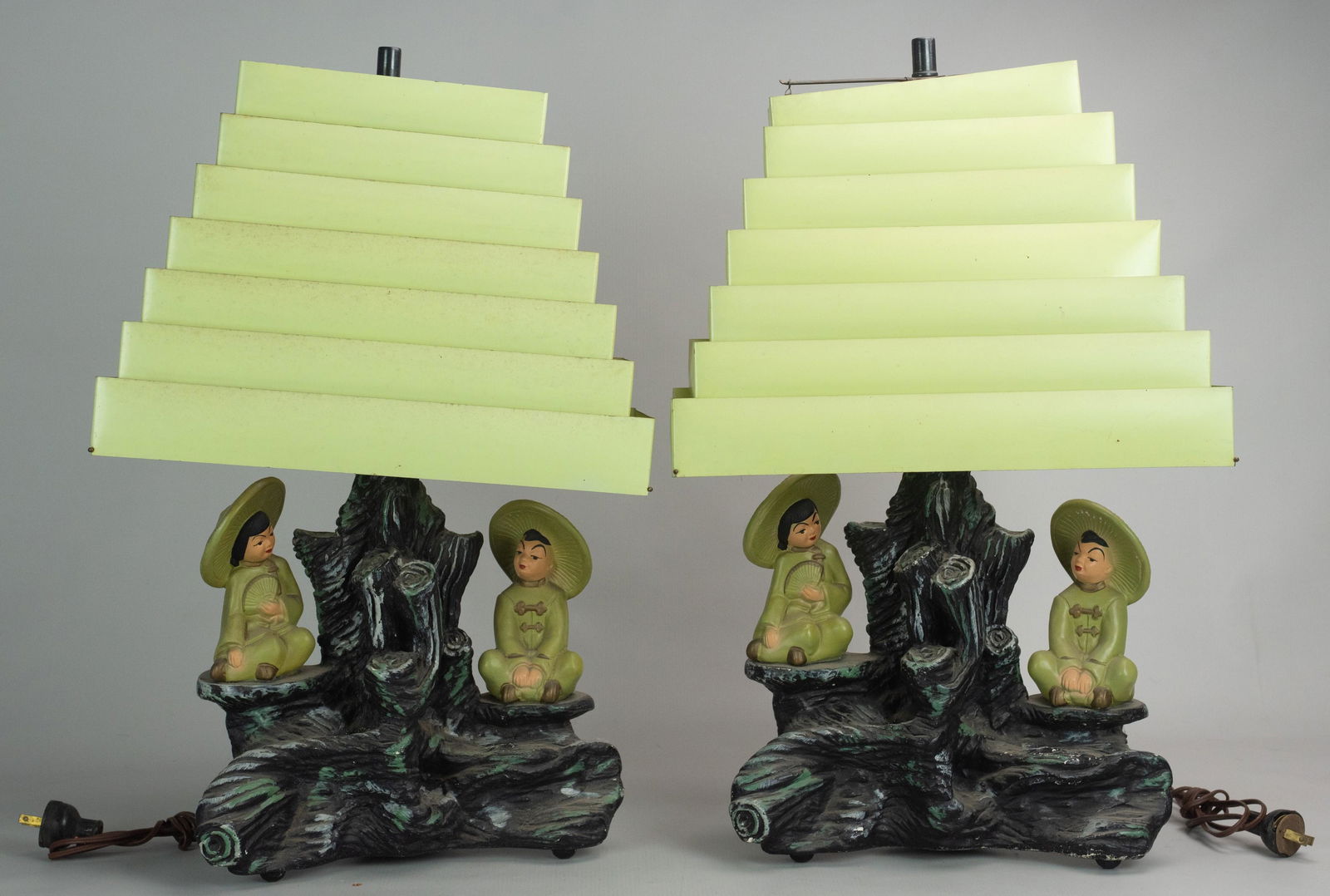 (2) Mid-Century Chalkware Chinese Figural Lamps: (2) Silvestri mid-century painted chalkware table lamps, 2 Chinese seated children, green metal Venetian blind shades (including one extra shade that needs to be restrung), dated '58, 22" h overall, m