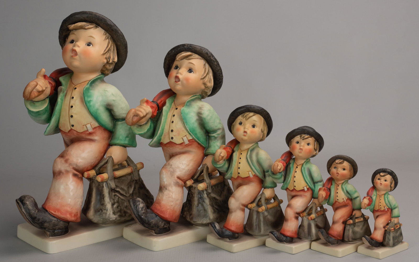 (6) Hummel Merry Wanderer Graduated Figures: (6) Goebel Hummel Merry Wanderer porcelain figurines, graduated sizes, 7/III artist signed (TMK7, 12"), 7/II (TMK5, 10-1/4"), 7/I (TMK3, 7"), 7/0 (TMK5, 6-1/4"), 11/0 (TMK5, 4-3/4"), 11 2/0 (TMK6, 4-1