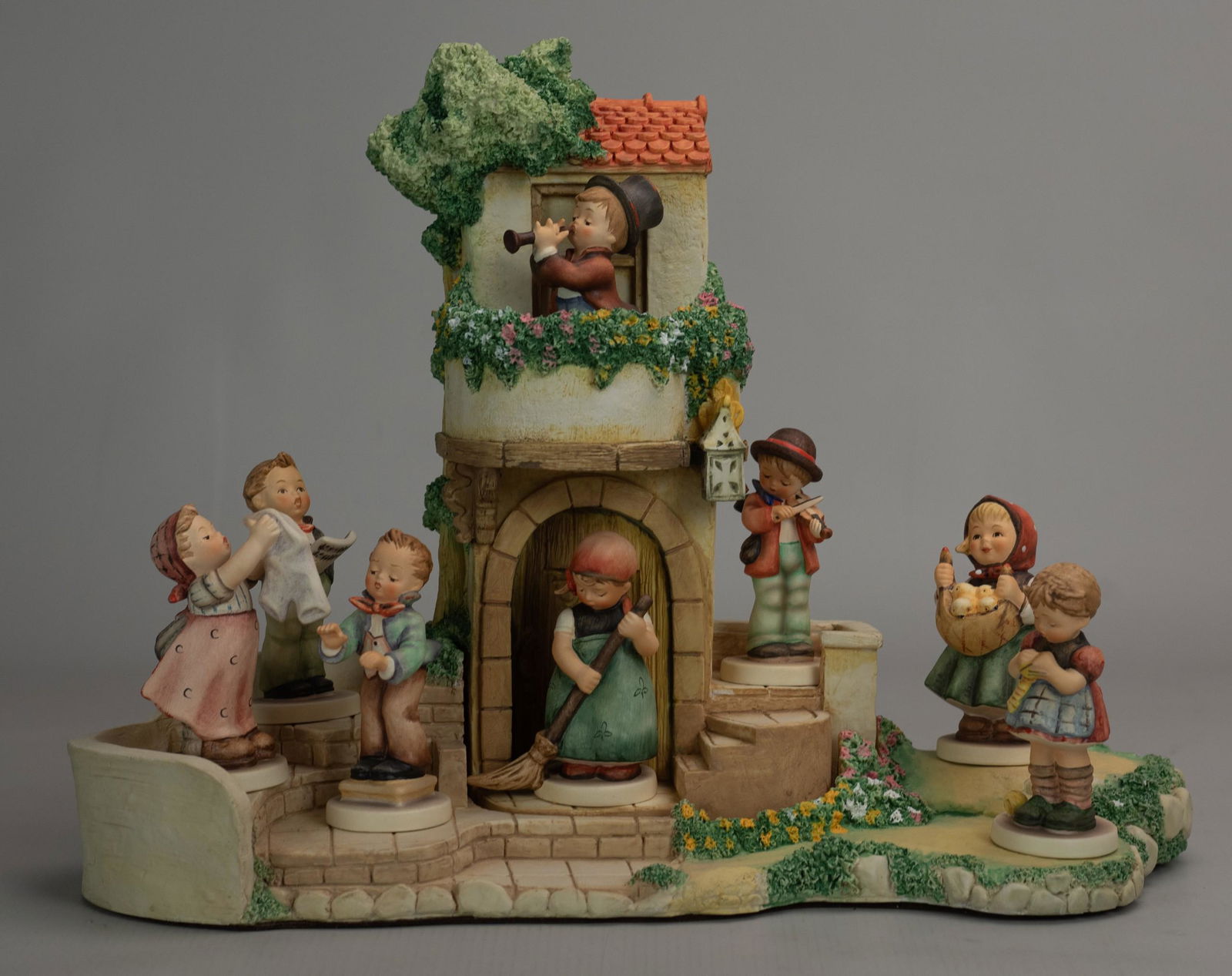 Hummel Torhaus Garten with 8 Figures: Goebel Hummel Torhaus Garten Hummelscape with removable building designed by Robert Olszewski, and (8) porcelain figurines, c/o Wash Day (321 4/0), Little Sweeper (171 /0), Little Fiddler (2 4/0), Sol