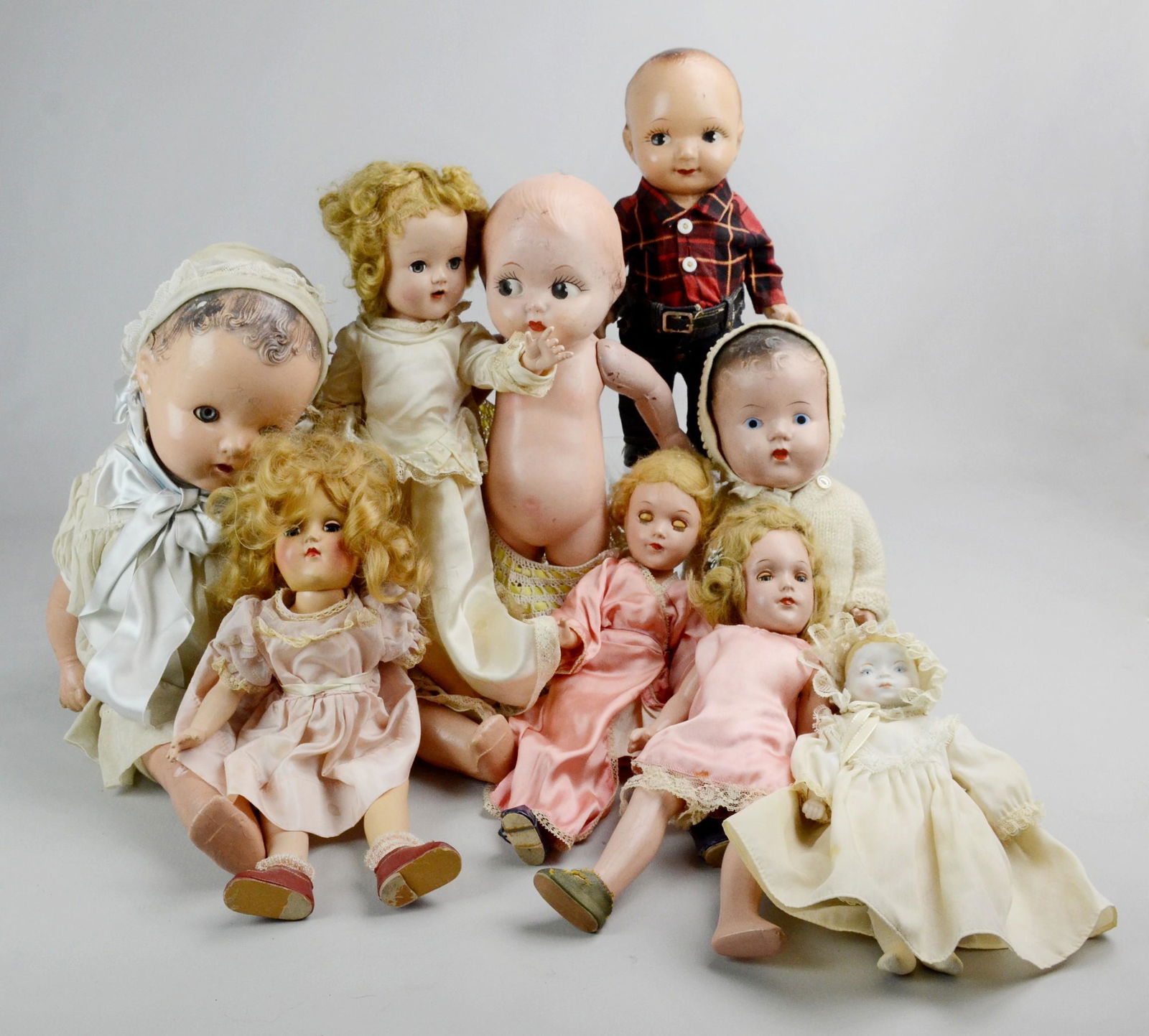 Composition, Plastic and Bisque Dolls: Composition, plastic and bisque dolls c/o ABC Toys doll with blue sleep eyes, unmarked plastic doll in silk wedding dress with blue sleep eyes, bisque head babydoll in cotton attire, Ideal doll in pin