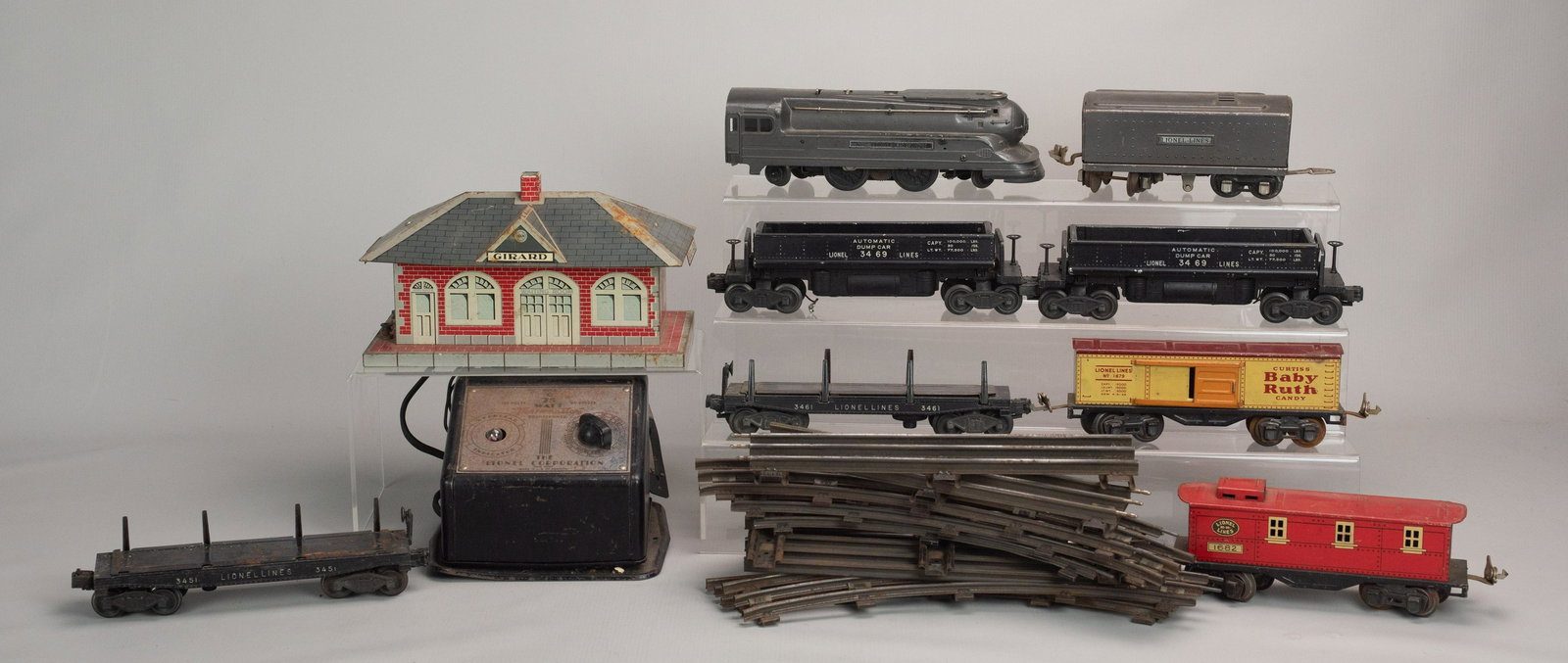 (8) Lionel Train Cars, Track, Station and Transformer: (8) Lionels train cars, track, station and transformer c/o 1688 Lionel Lines locomotive, Lionel Lines RR 1682 car, Curtis's Baby Ruth Candy Lionel Lines #1679, (2) flatbeds, (2) dump cars, Girard stat