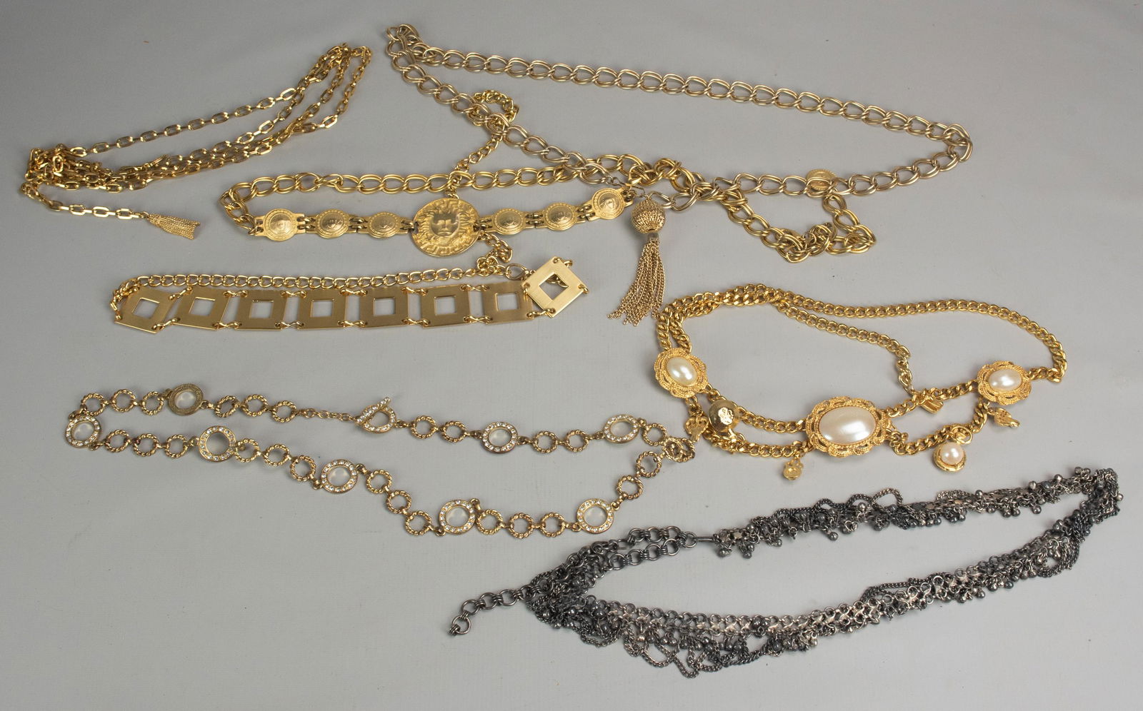 (7) Chain Metal Belts: (7) Chain metal belts, most in gold tone, (1) Versace style with greek key.