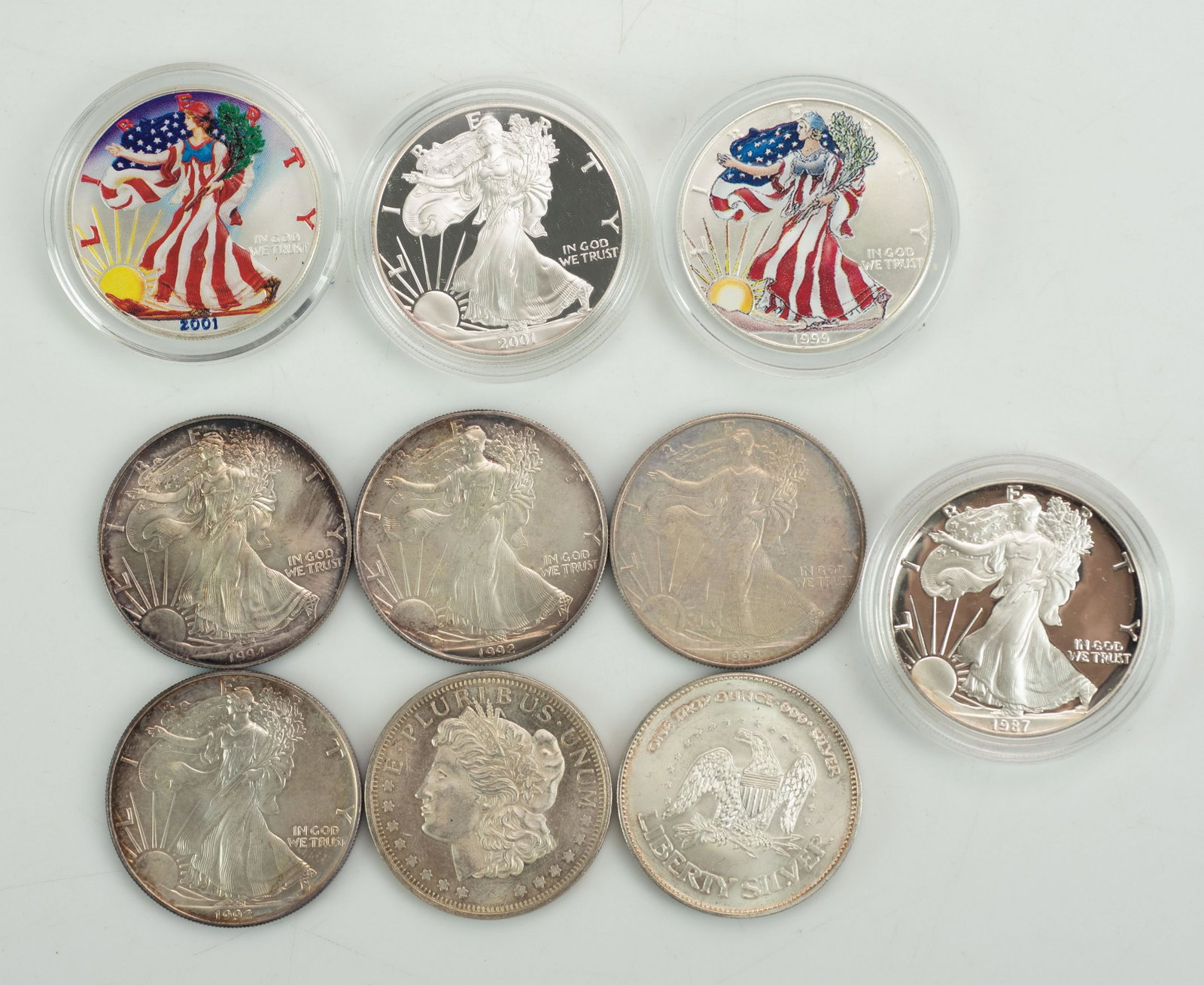 (10) Silver Coins: (2) 1999, 2001 colorized US silver Eagle dollars, (1) 1987, (3) 1992, (1) 1994, (1) 2001 silver Eagle dollars, (2) other fine silver rounds