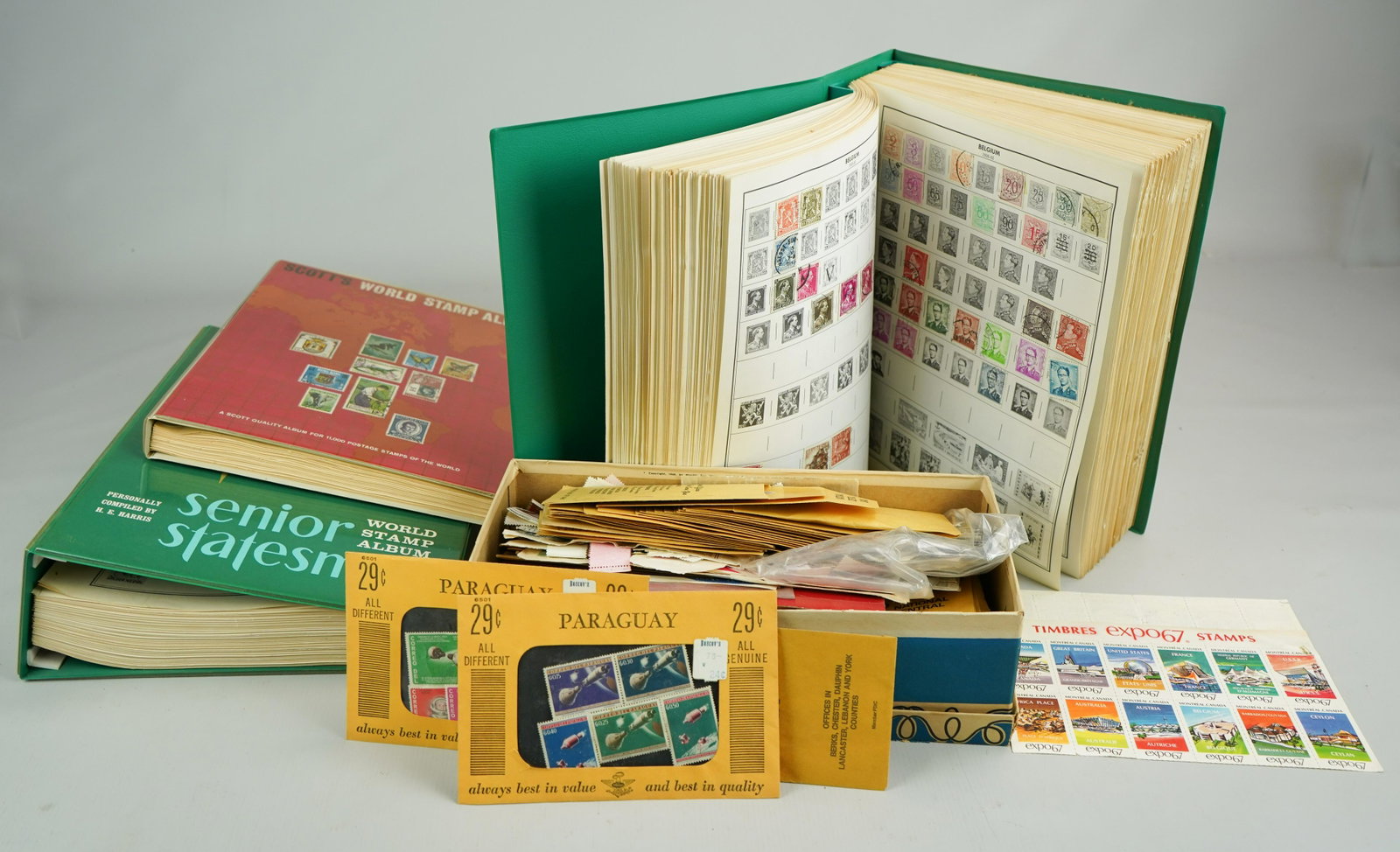 Mixed US & foreign Unused and Used stamps: Shoebox of mixed US & foreign unused and used stamps, (2) HE Harris World Stamp catalogs (10-20% full), Scott World Stamp Album,