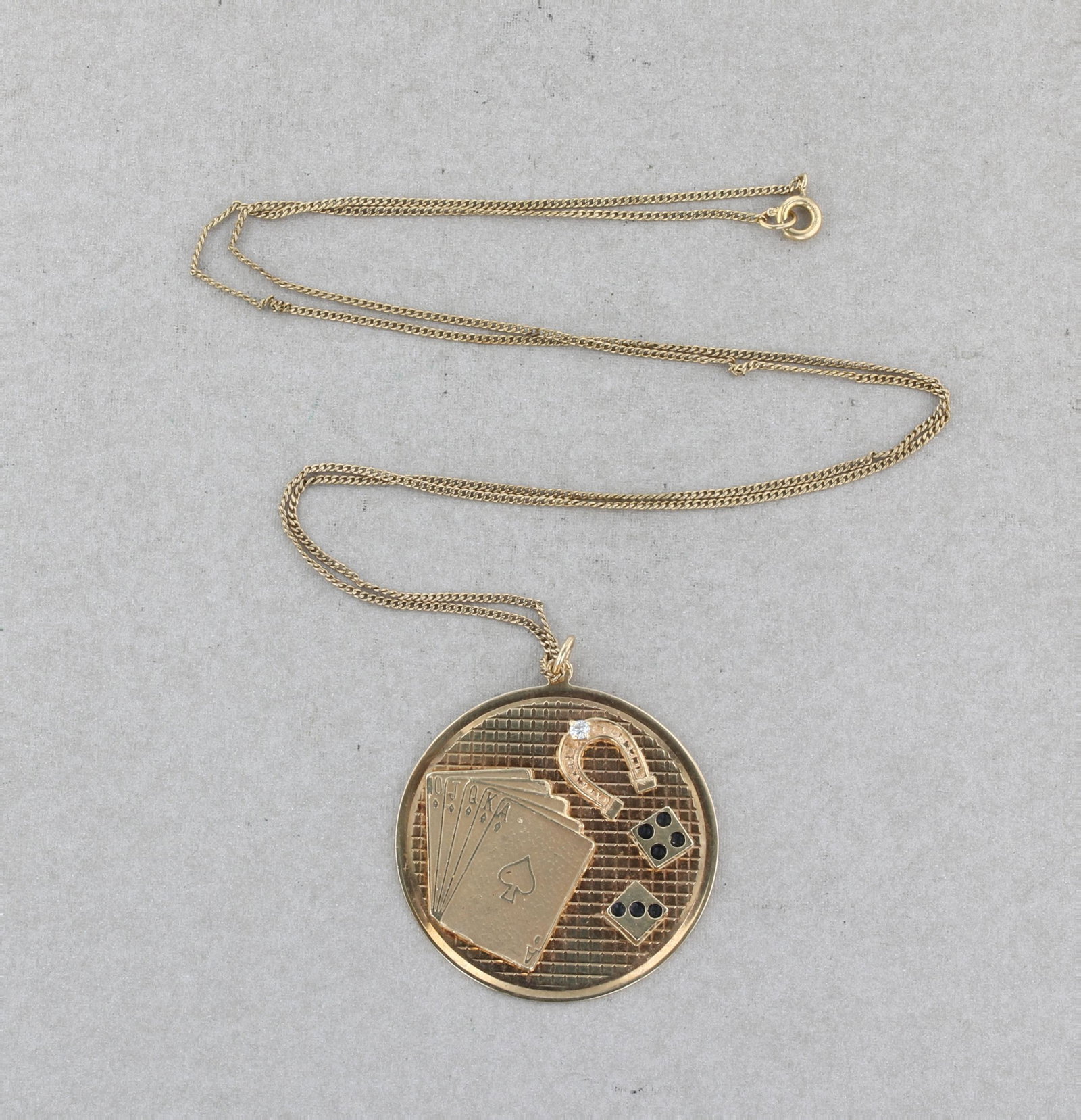 14K Round Lucky Vegas Gambling Medal: 14K 37mm in diameter round medal pendant with a 2.3mm round diamond. This very interesting pendant's design includes a deck of cards, dice, and a lucky horseshoe. 9.5 Dwt. included is a Gold filled ch