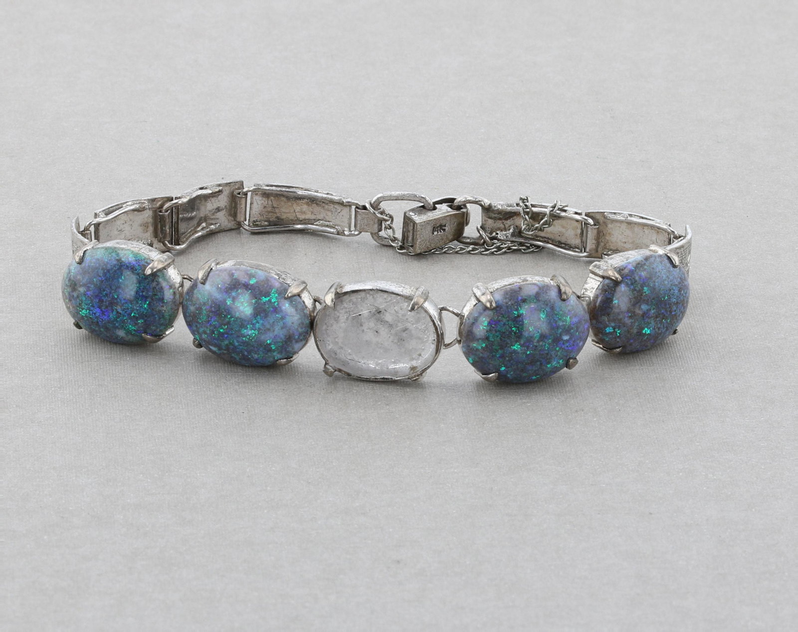 Mixed Metal Opal Braclet: (1) White gold and silver bracelet, marked 14K at the clasp. Set with four appox. 15x12mm black /grey opals. Total weight: 11.3 Dwt. (missing one opal)