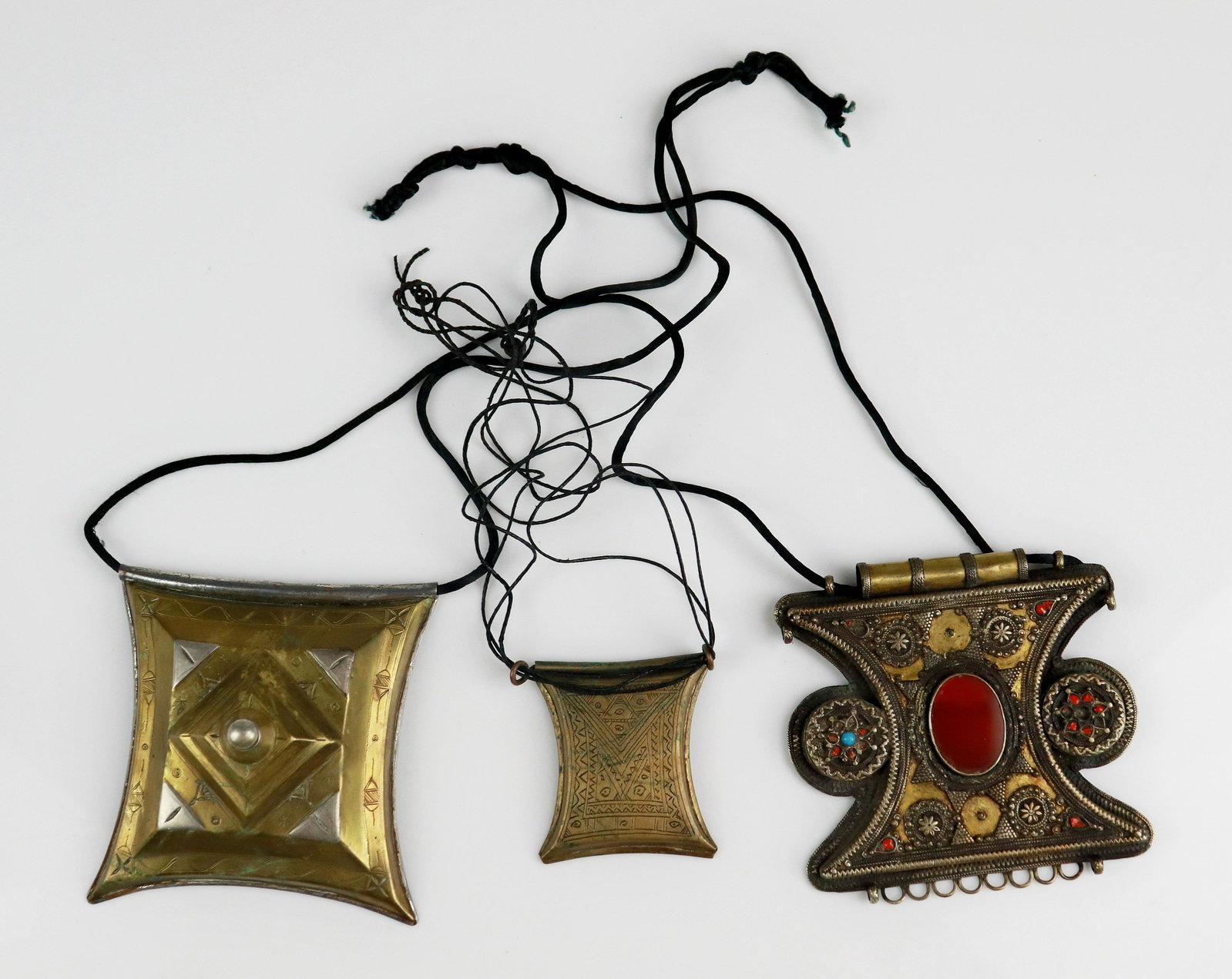 (3) Pc Tscherot Tuareg Gris Gris Necklace: (3) Pc lot of Tscherot Gris Gris Tuareg Necklces , Brass, copper Etched with tribal symbols and (1) Brass necklace encrusted with carnelian and others with losses.