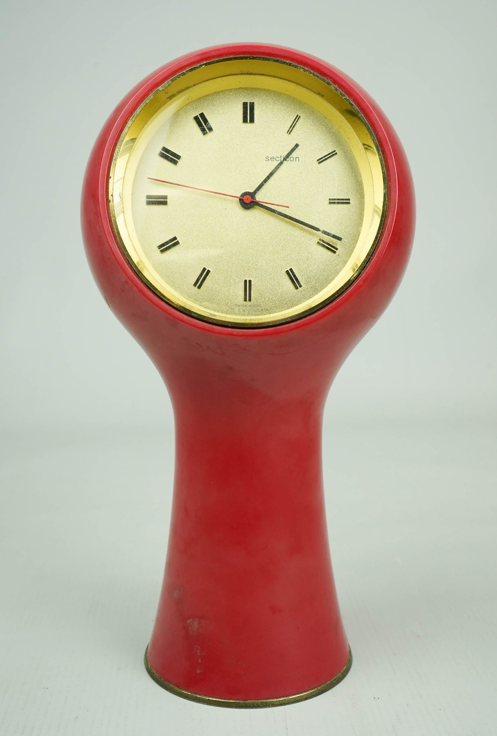 Secticon Mid Century Modern Desk Clock: Secticon mid century modern desk clock, designed by Angelo Mangiarotti, made by Portescap, Le Porte Echappement Universal La Chaux De Fonds S. A., red plastic casing, gilt clock face, black and red ha