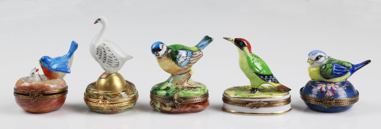 (5) Bird Decorated Porcelain Trinket Boxes: (5) Bird decorated porcelain trinket boxes c/o (1) Artoria Limoges marked goose on golden egg with golden egg interior, Blue Jay and babies nest form trinket marked Limoges at interior, blue bird and 