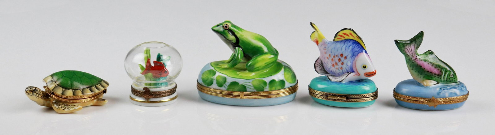 (5) Aquatic Life Porcelain Trinket Boxes: (5) Aquatic life porcelain trinket boxes c/o frog and lily pad decorated box marked Limoges Chamart at interior, tropical fish topped trinket marked Limoges, sea turtle form trinket with porcelain bab