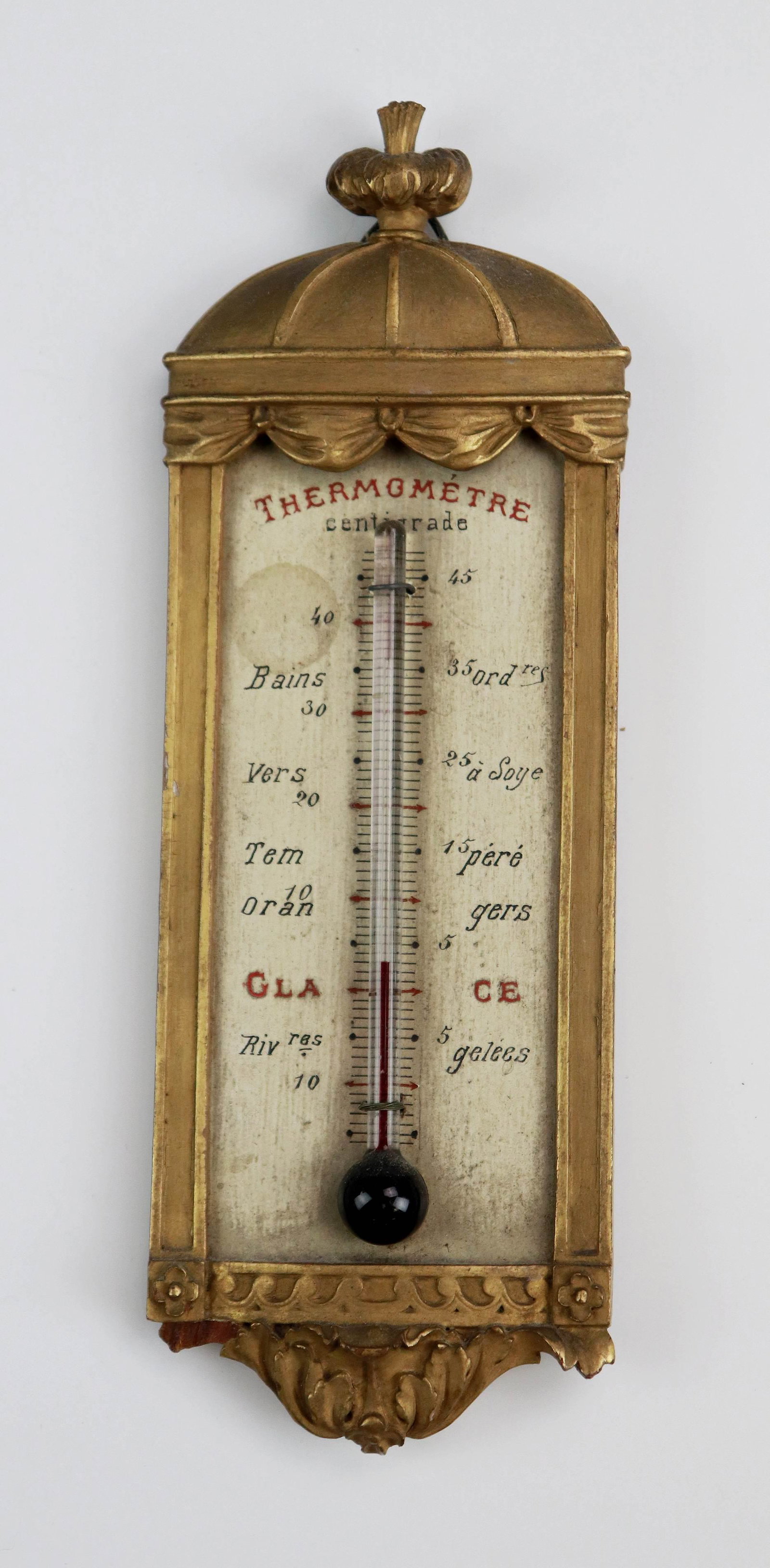 19th c. French Carved Gilt Wood Thermometer: 19th c. French carved gilt wood thermometer, illegible retailer printed on silk at back, 8"x2-5/8", small piece missing bottom left.