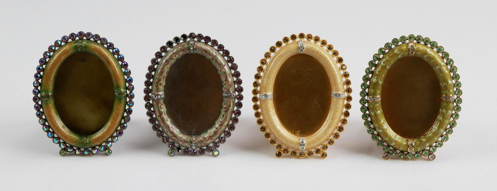 (4) Oval Guilloche Jay Strongwater Frames: (4) Oval Guilloche Jay Strongwater frames with Swarovski crystal surround, all model 5116 in varied color and enameled design, (1) with 4 missing crystals. 3-5/8" ea.