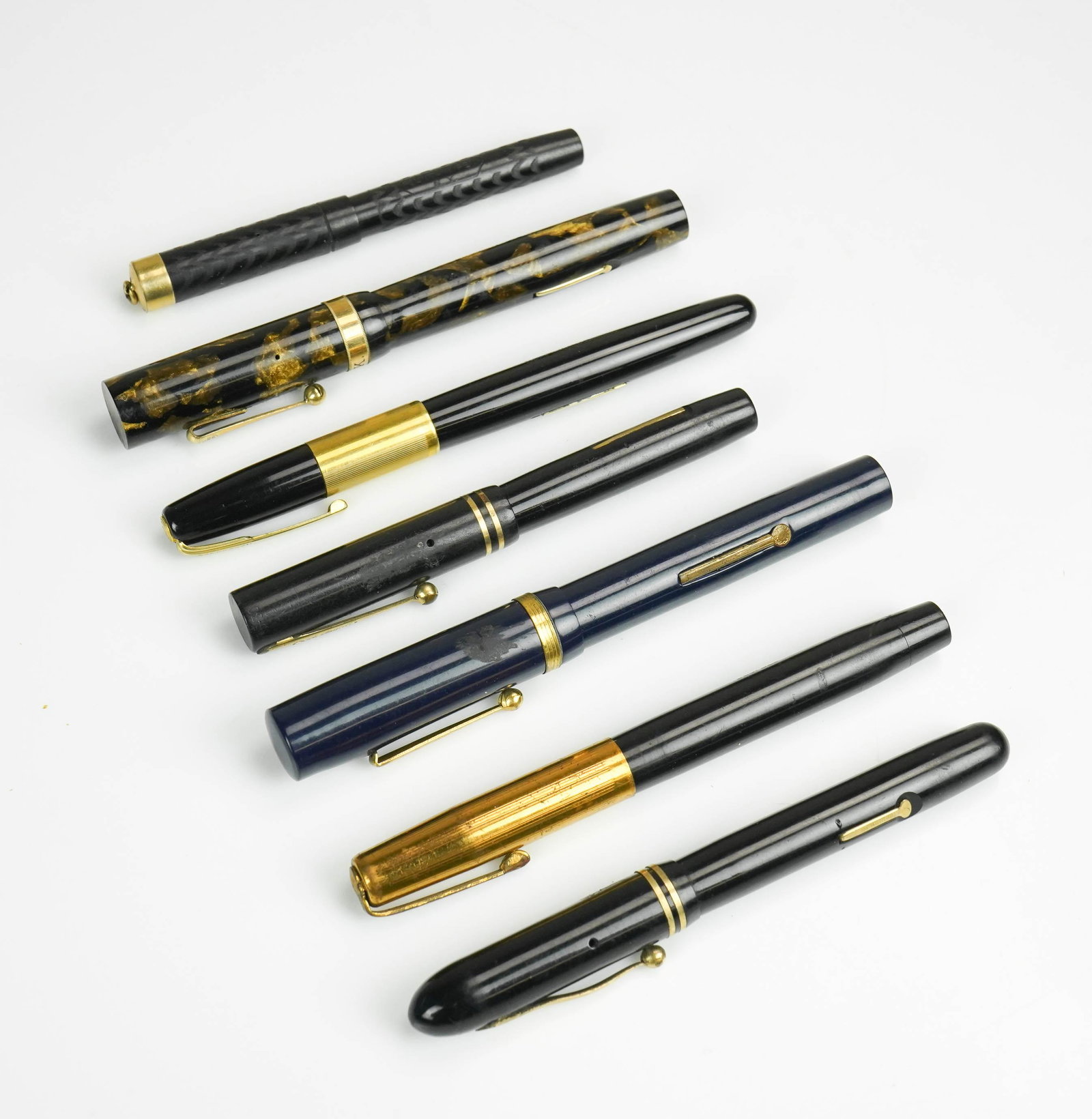(7) Fountain Pens: (7) Fountain pens c/o Moore Pen Co Moore's maniflex pen with gold initialed band at caps end and gold nib, Spencerian pen no. 1561590 with gold nib, Park Row pen with gold nib, W.A Sheaffer pen, Parke
