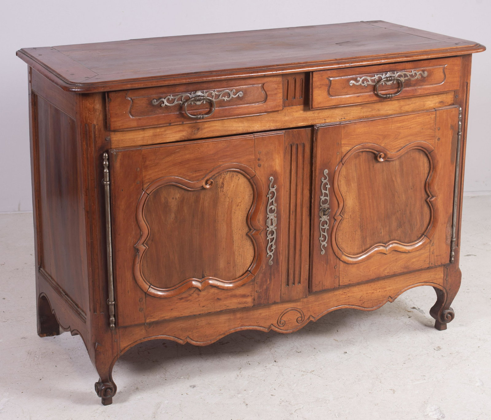 18th c Walnut French Provincial sideboard: Carved Walnut French provincial sideboard, top with mitered breadboard ends, base with two drawers with carved panels over two doors with shaped and scalloped panels, 18th c, with some repairs, 54"w, 