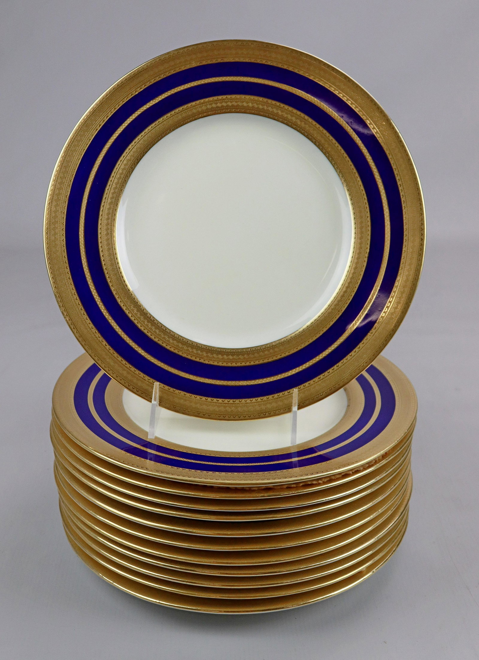 (12) Mintons for Tiffany and Co. Dinner Plates: (12) Mintons for Tiffany and Co. dinner plates in cream with cobalt and gilt edge in heart and greek key pattern, 10-1/4" diam, one with hairline through center.