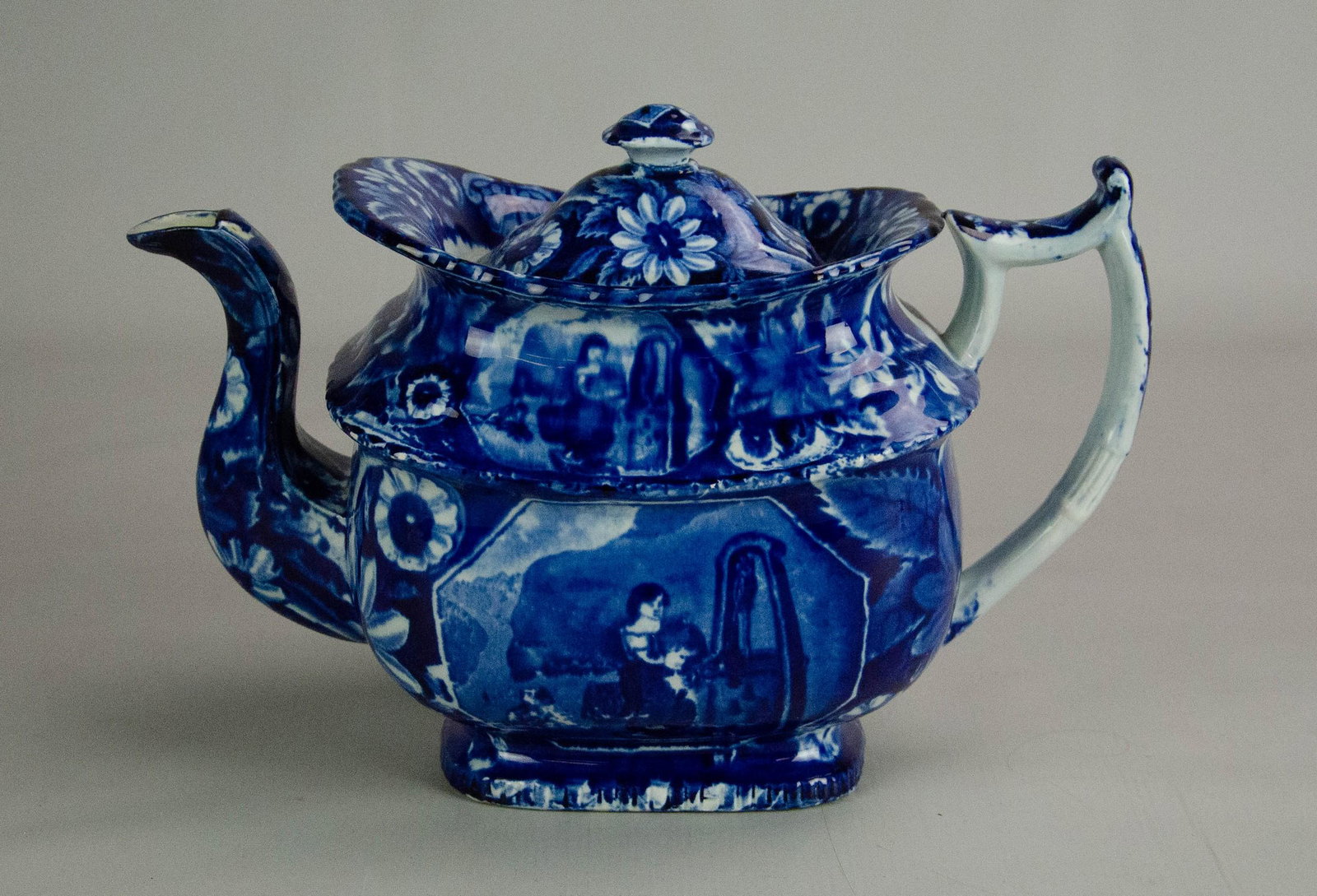 Blue Staffordshire Teapot: Blue Staffordshire teapot, young girl with dog at well scene, unsigned, some repairs around lid flange, base with discolored hairline, 12-1/4" l x 8" h