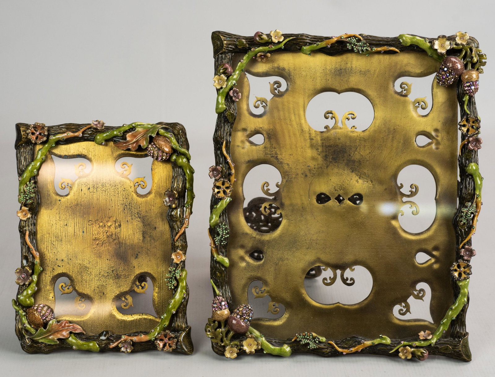 (2) Enameled Jay Strongwater Frames: (2) Enameled Jay Strongwater frames in Swarovski crystal studded woodland decoration including foliage, acorns, flowers and branch form surround, 10-1/2"x8-1/2" and 7-1/2"x6", larger with stand that n