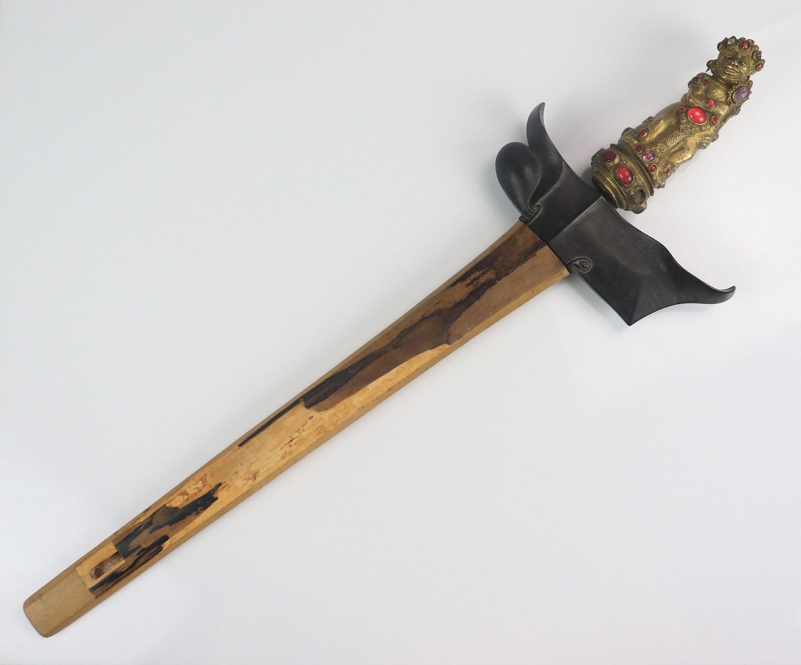 Asian Kris Sword: Asian Kris sword, gilt metal figural handle with faux gemstones (some missing), etched wavy blade (some rust), ebony hilt, wood sheath (with losses), 20" l