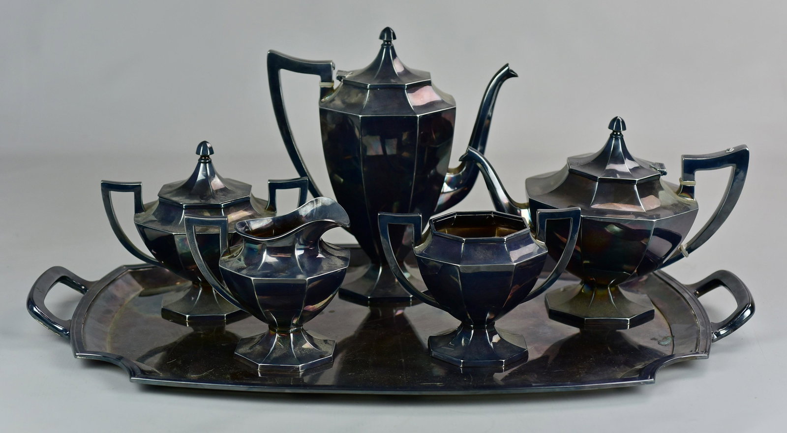 (6) Pc Wilcox Silverplate Tea and Coffee: (6) Pc Wilcox silverplate tea and coffee service to include 10" coffee pot, 7-1/2" tea pot, 6-1/2" sugar, 5" creamer, 4-3/4" waste bin and 25" double handled tray, all items in multi-sided form with s