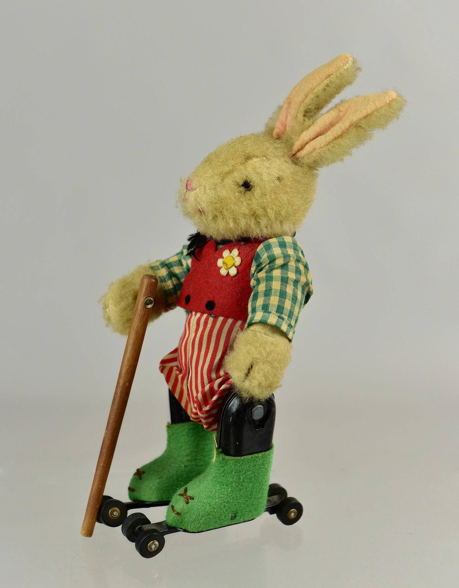 Schuco-Rolly Rabbit Skater: Schuco-Rolly rabbit skater with mohair composition, glass eyes, tin body and appendages, cotton and wool attire with daisy at lapel and stick in hand. Marked under foot Made in US Zone Germany DBGM. I