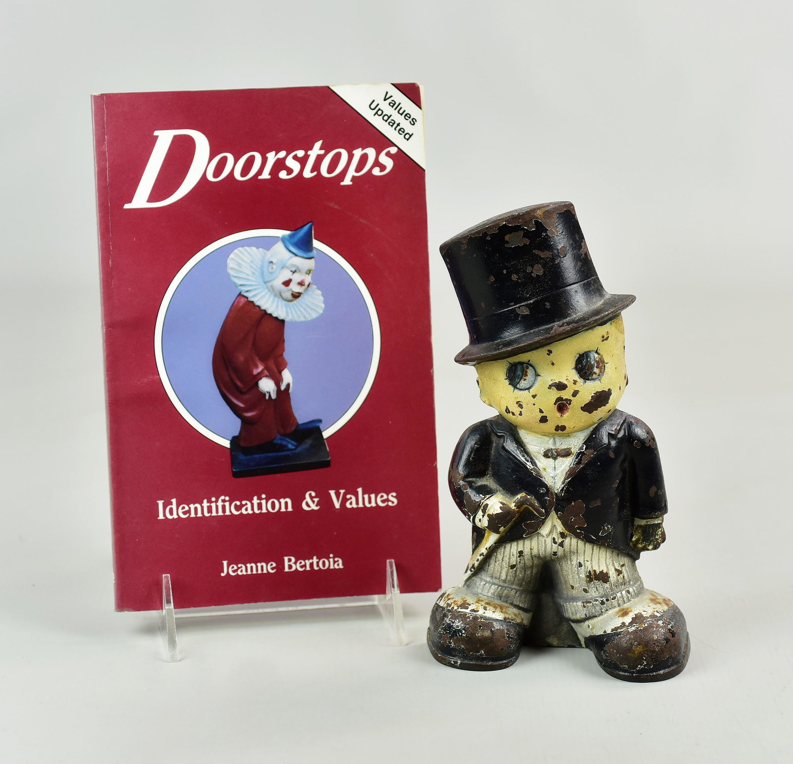 A Judd Co. Boy in Tuxedo Door Stop: A Judd Co. boy in tuxedo cast iron figural doorstop in polychrome paint, numbered 1262, 7-3/4" h x 4-1/4", missing wood wedge. Also includes Jeanne Bertoia " door Stops"
