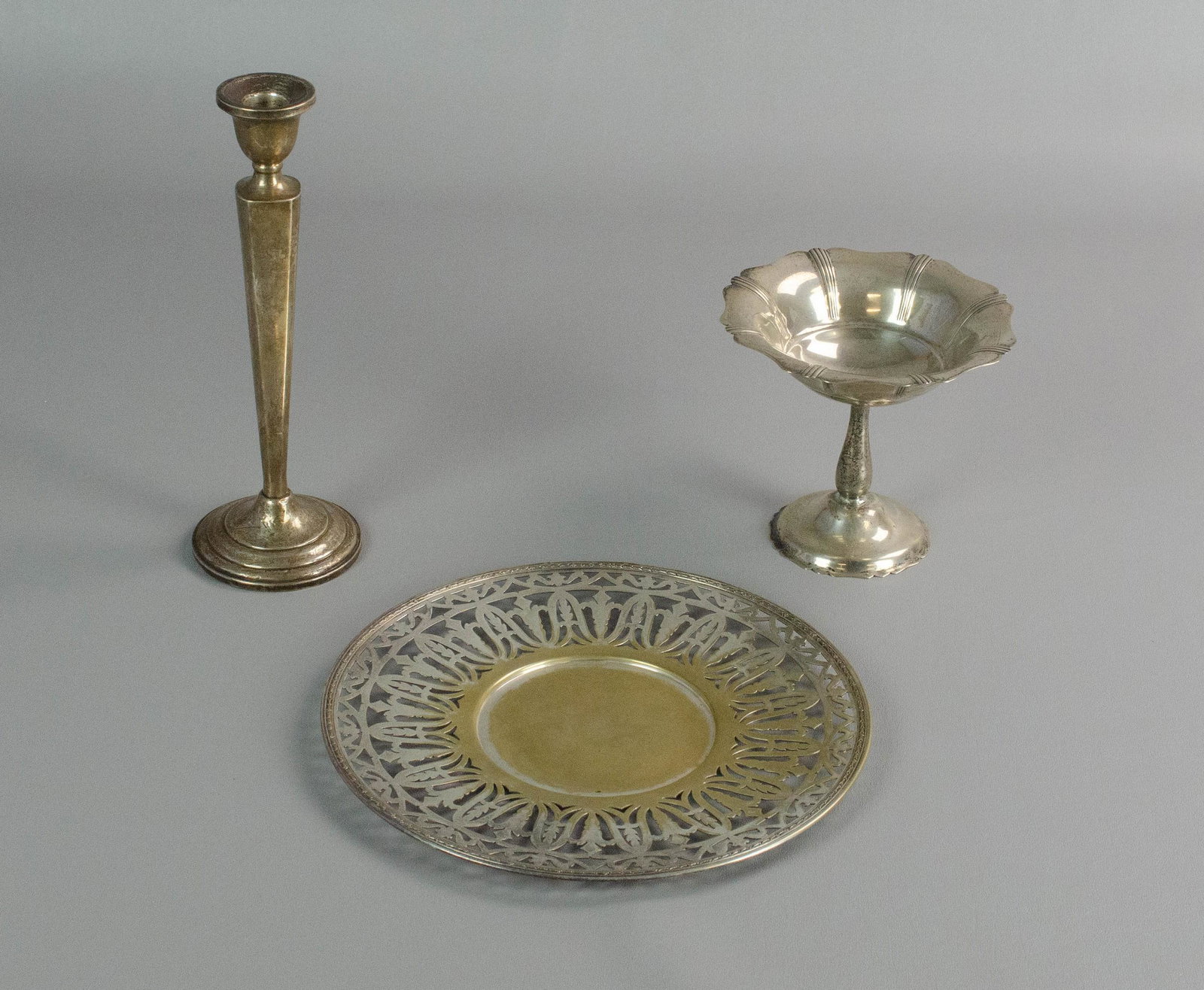 Sterling, Plate and Weight Table Items: Sterling, plate and weight table items to include sterling scallop edge compote, 5-1/4" h, 5-3/4" diam, Benedict Period Plate reticulated plate, 10" diam and single cement filled candlestick with init