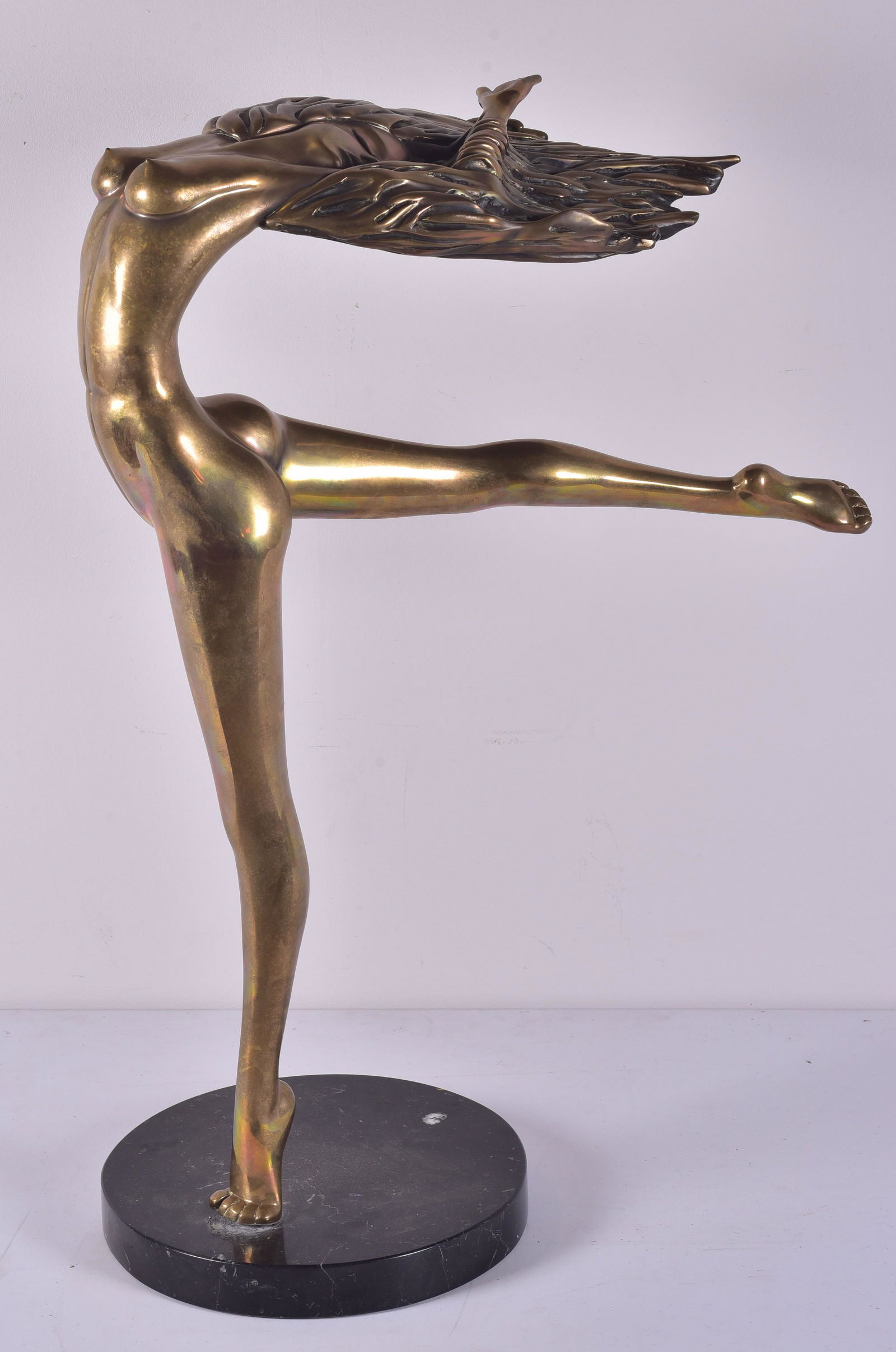 Tom Bennett Polished Bronze Nude: Tom Bennett (1925) polished bronze sculpture depicting nude woman in arabesque position with arms and hair thrown back, signed along back of grounded foot, 18/100, on black marble base, 31" H