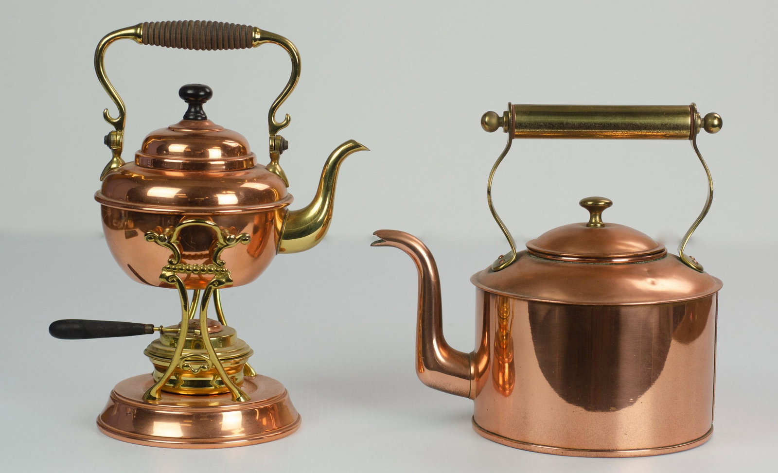 (2) Copper Kettles: (2) Copper kettles to include Empress Ware copper tea kettle on stand with turned wood handle, brass mounts and brass burner with copper cover and unmarked copper kettle with brass handle, unmarked.