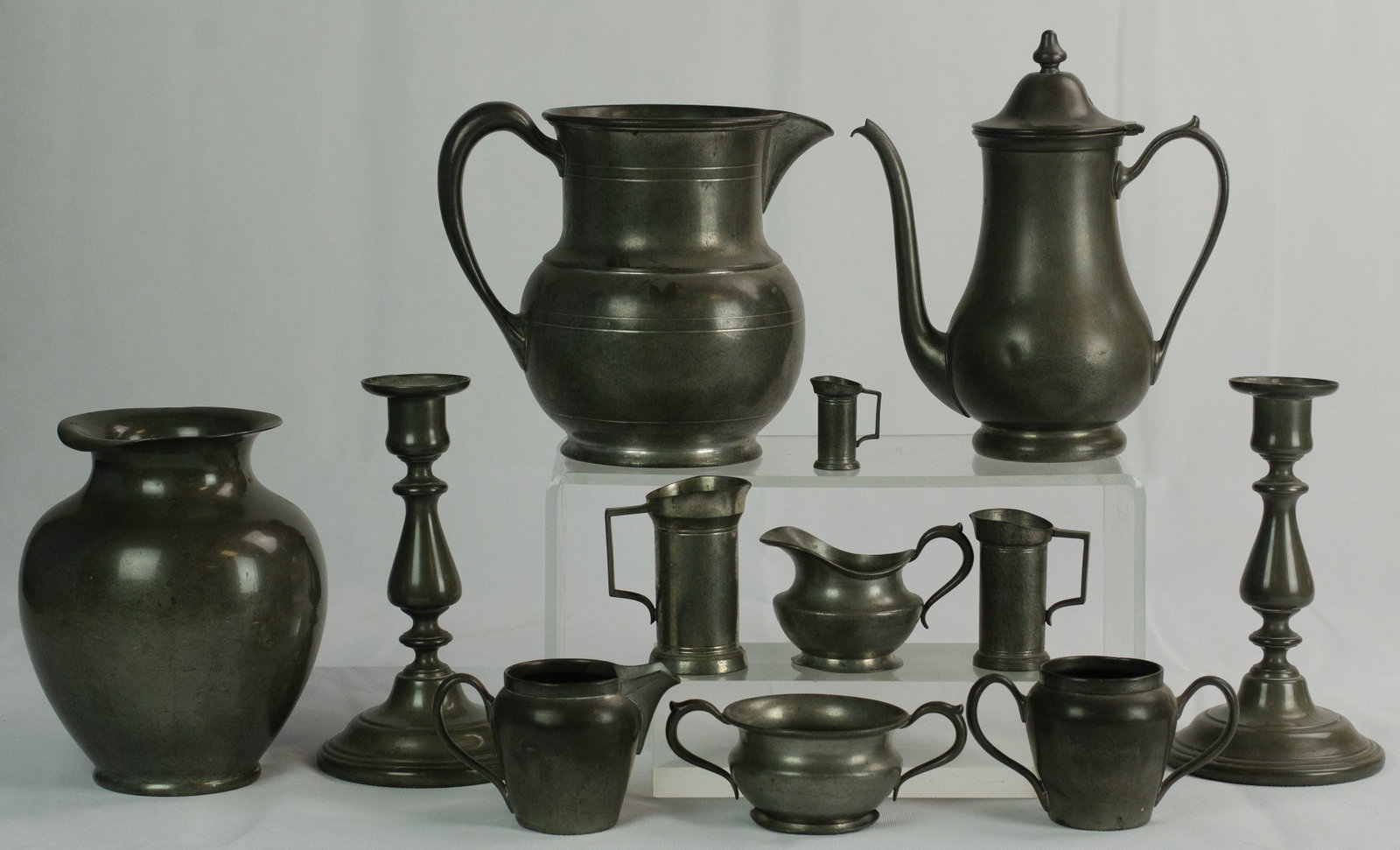 (12) Pewter Table Items: (12) Pewter table items to include International Pewter candlesticks, 8-1/4" h, Reed and Barton pewter vase 5074, Pilgrim pewter 5-pint pitcher, (3) Royal Holland Pewter measures, C.A Woodward Taunton