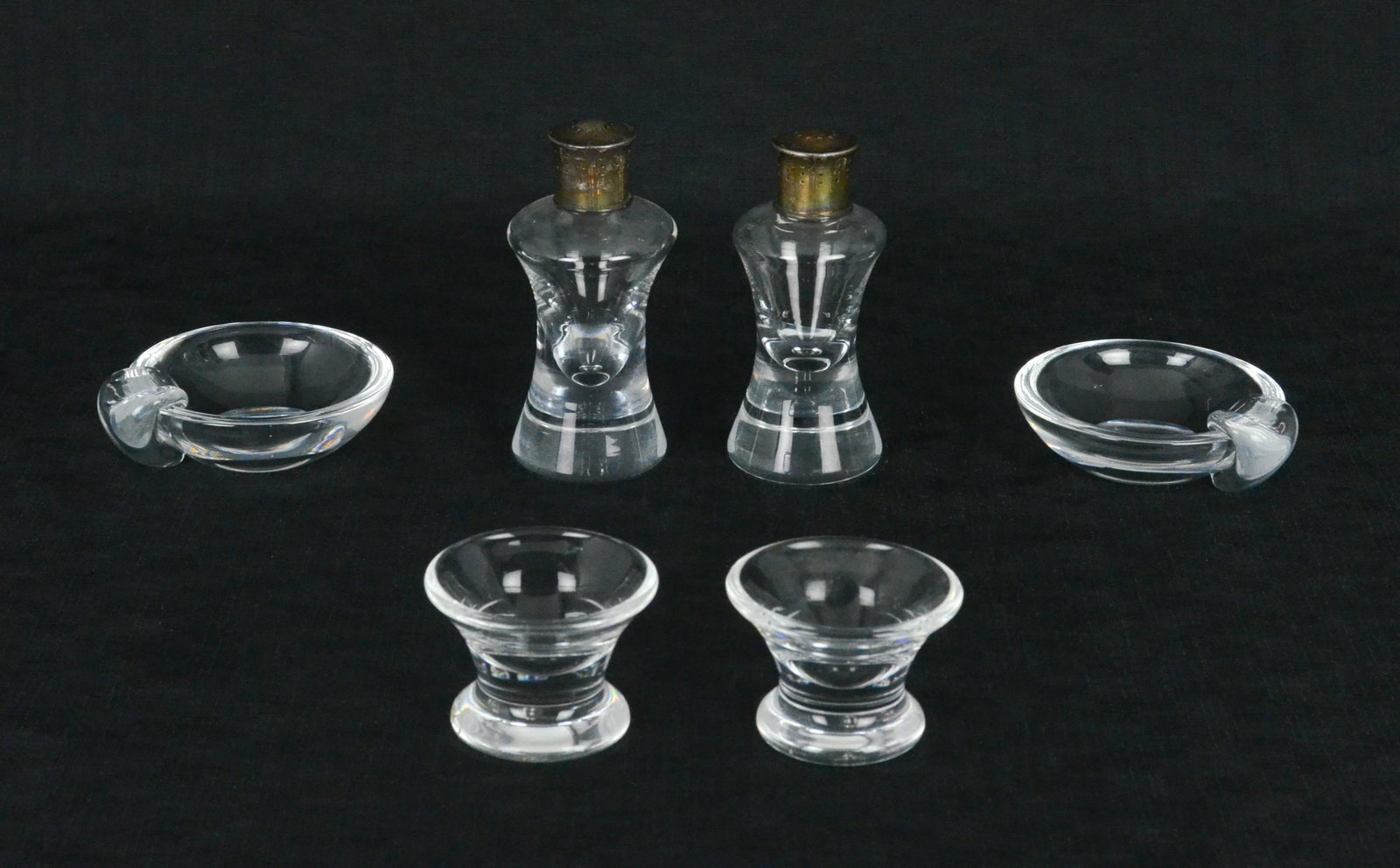 (6) Steuben Table Items: (6) Steuben table items to include (2) handled dishes, 3-1/2", (2) small raised bowls, 2"x2-1/2" and PR shakers, 4-1/2" h, all items signed at underside