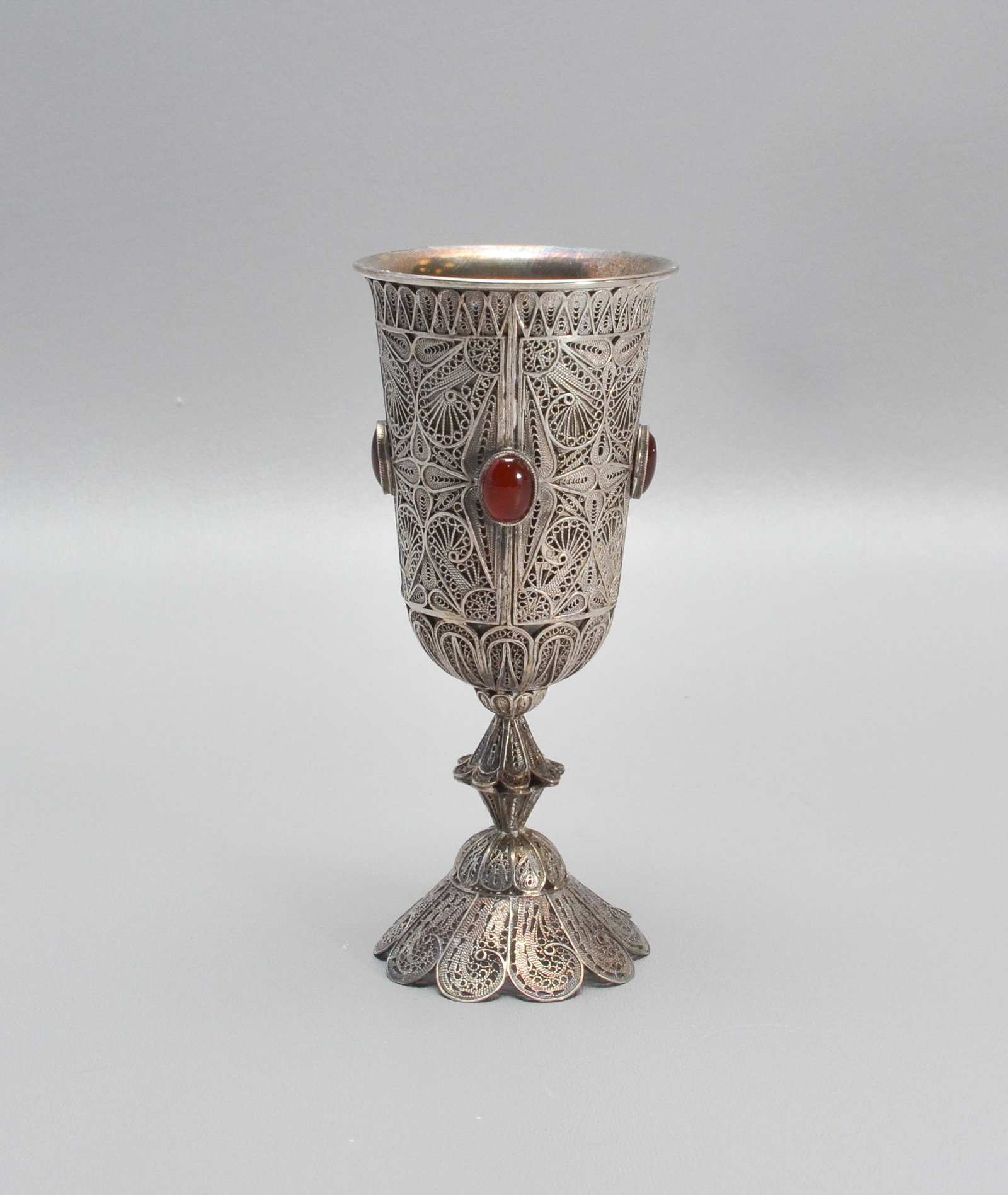 Israel Sterling Silver Kiddush Cup: Israeli Judaica sterling silver Kiddush Cup goblet, applied filigree around the bowl, stem, and base, bowl set with 4 oval cabochon stones, marked on base "Made in Israel 925", 5-3/4" h, 4.995 TO