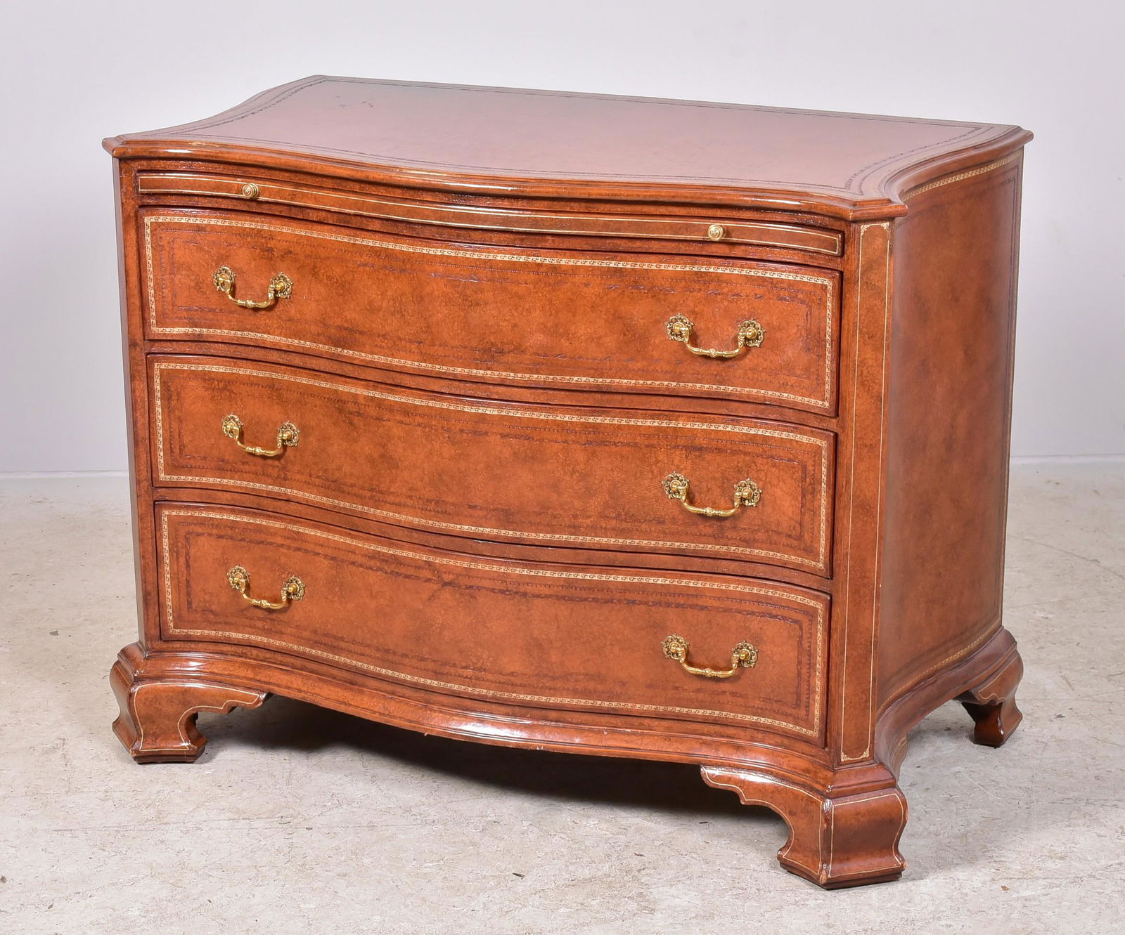 Maitland-Smith Serpentine Commode: Maitland-Smith serpentine three drawer georgian style commode with tooled leather top and drawer front, pull out serving slide, 42" w x 24" dx 33-1/4" h