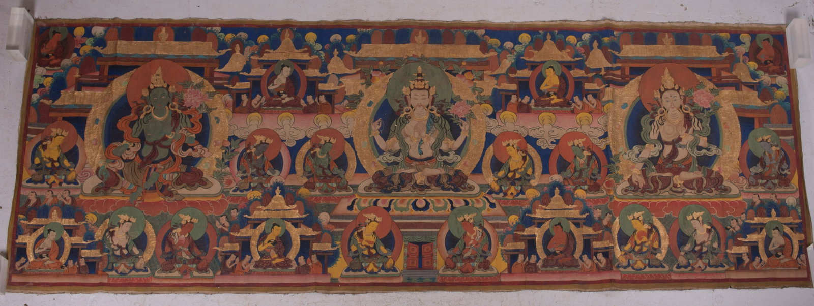 11 Foot Tibetan Buddhist Thangka Painting: 11 Foot Tibetan Buddhist Thangka Painting depicting (3) large images of deities and numerous figures, oil and gold gilt on linen, unframed, measures 50" x 136", good condition, creases from rolling. F