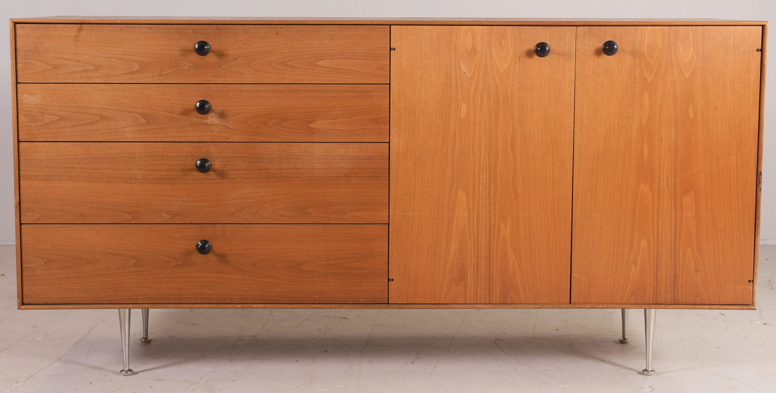 George Nelson for Herman Miller walnut credenza: George Nelson for Herman Miller walnut credenza, chrome feet, two doors flanked by 4 drawers, 33-1/4"h x 67-1/2"w, wear to finish, scratches, watermark on top