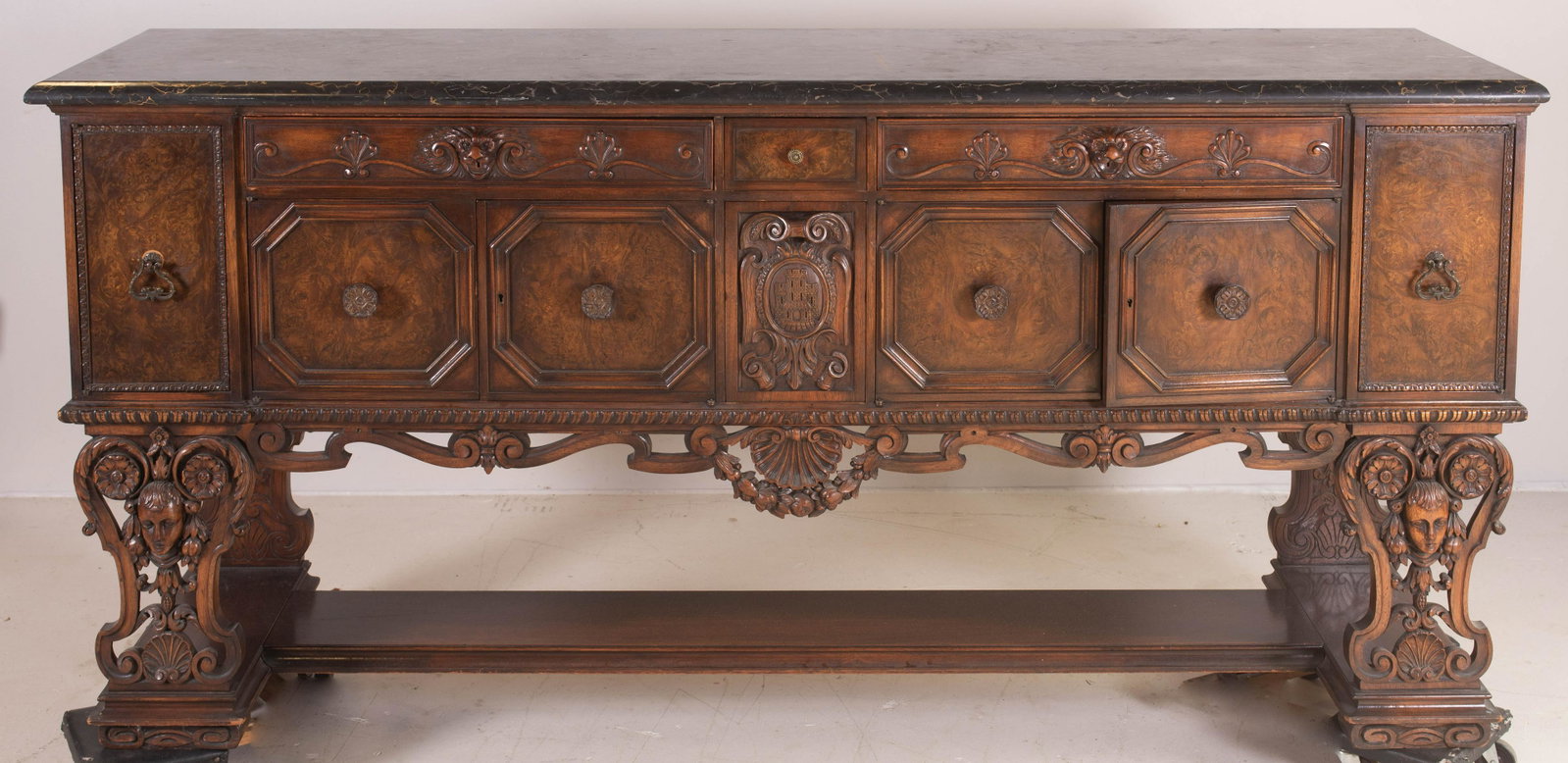 Burl walnut figural carved Renaissance Revival: Burl walnut figural carved Renaissance Revival sideboard, black marble top, case fitted with drawers and storage doors, over a stretcher base with figural carved supports at front, early 20th c, 84"l 