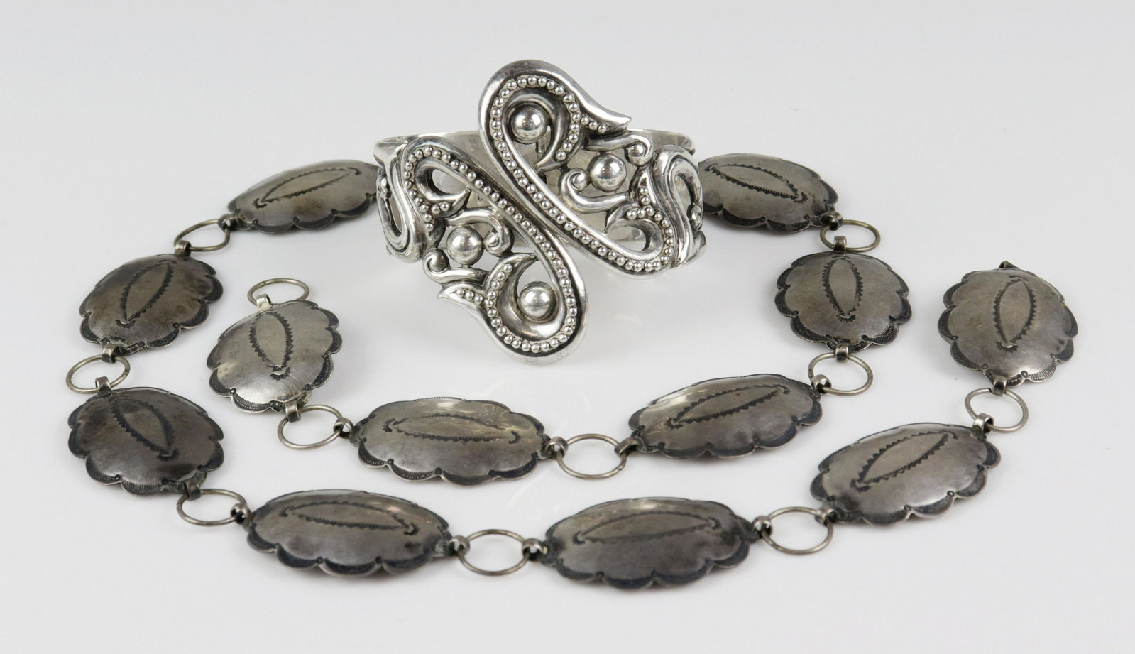 Silver Concho Belt and Clamp Bracelet: (1) Sterling Silver Spring, clamper bracelet, with paisley pattern. Signed Taxco. and (1) unsigned 30" Silver Concho Belt; Fred Harvey era, orig. owner worked as Fred Harvey Girl in SF NM, Purchased a