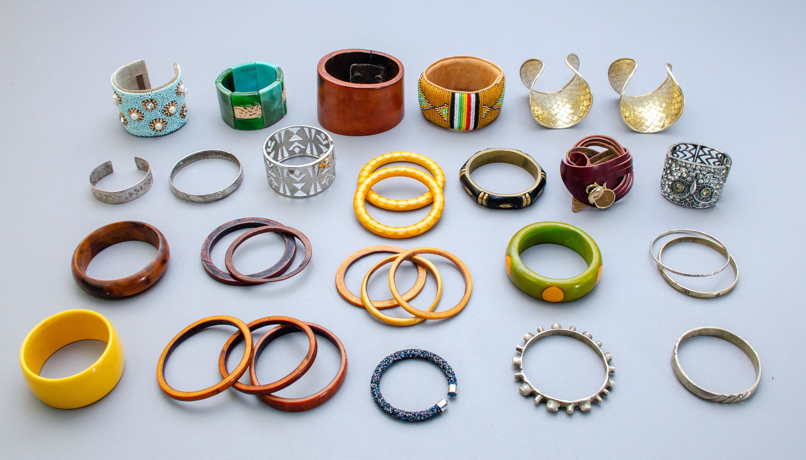 Wood, Bakelite, and Metal Bangles: Large lot of bangles (10) Wood, (4) Bakelite-Acrylic and (10) Metal Bangles, (1) stretch bracelet, (1) leather bracelet, (2) woven cuff bracelets, (1) Kenyan seed bead leather bangle and (1) Sam Dupon