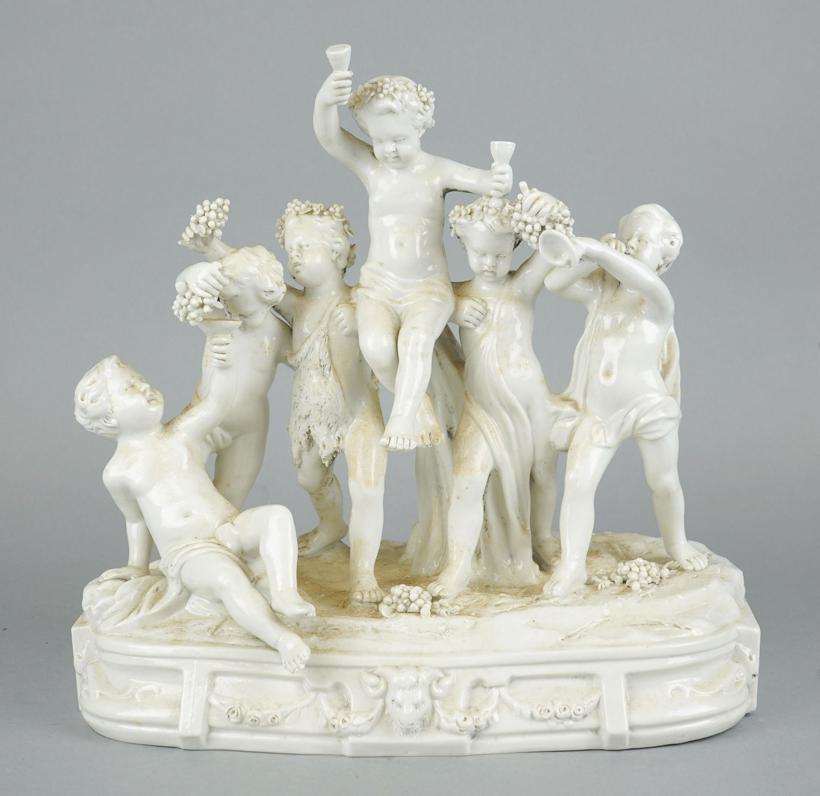 Capodimonte Blanc De Chine Figural Grouping: Capodimonte blanc de chine porcelain figural grouping, six putti with grapes & wine, 13-1/2" w x 13" h