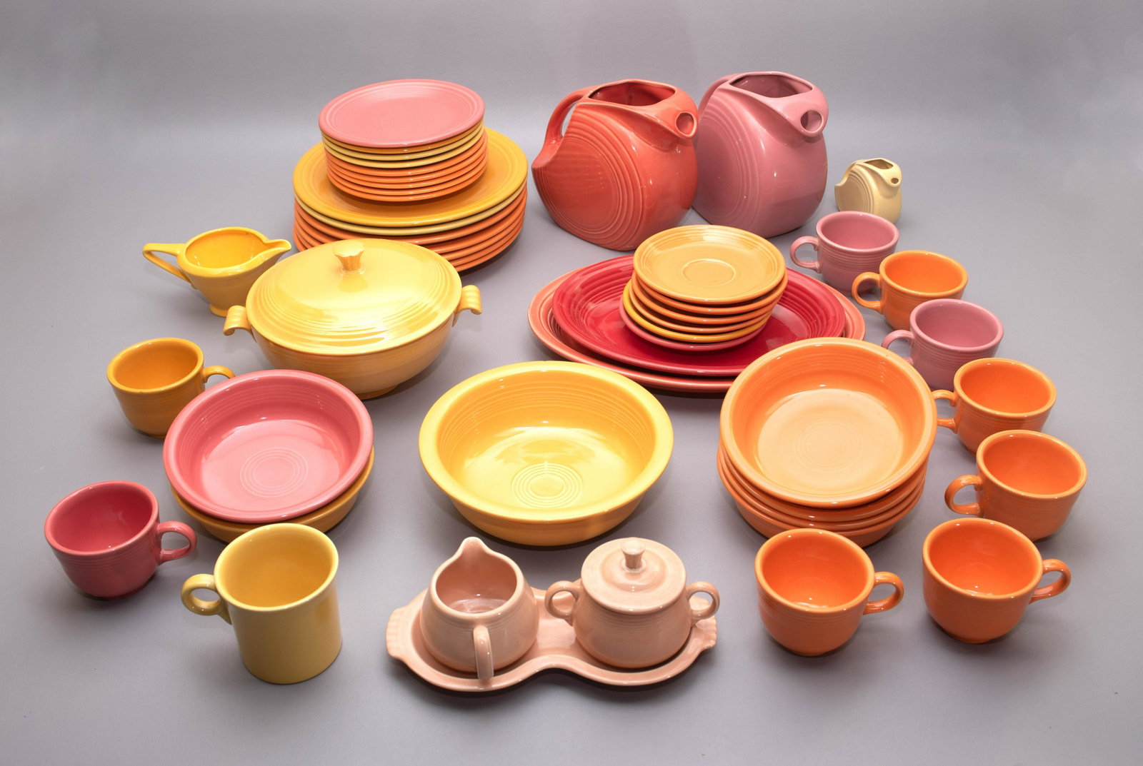 (47) Pcs Homer Laughlin Fiesta Dinnerware: (47) Pcs Homer Laughlin Fiesta dinnerware, including plates, cups, saucers, mug, platters, pitchers, sugar & creamer on tray, shakers, bowls, one Fiesta style creamer