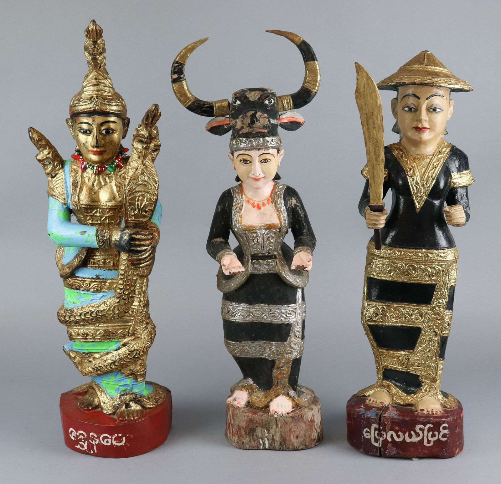 (3) Thai Carved Wood & Painted Statues: (3) Thai carved & painted wood statues, woman with bull headpiece, woman with sword, woman with snake, tallest 24-1/2" h, chips & cracks, paint loss