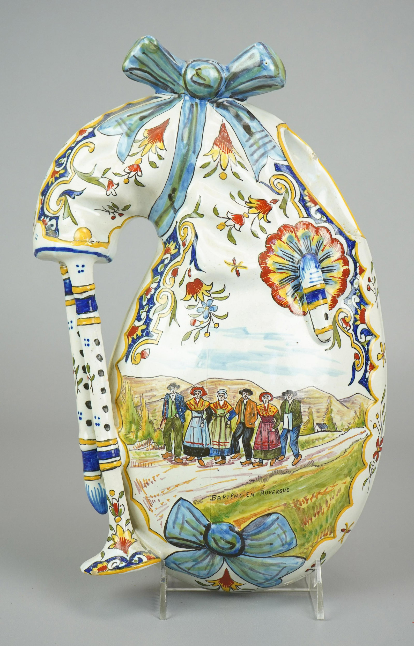French Faience Bagpipe Form Wall Pocket: French Faience bagpipe form wall pocket vase, tin glazed earthenware, polychrome decorated with floral designs surrounding scene of villagers walking on road, "Bapteme en Auvergne", marked on back "Au