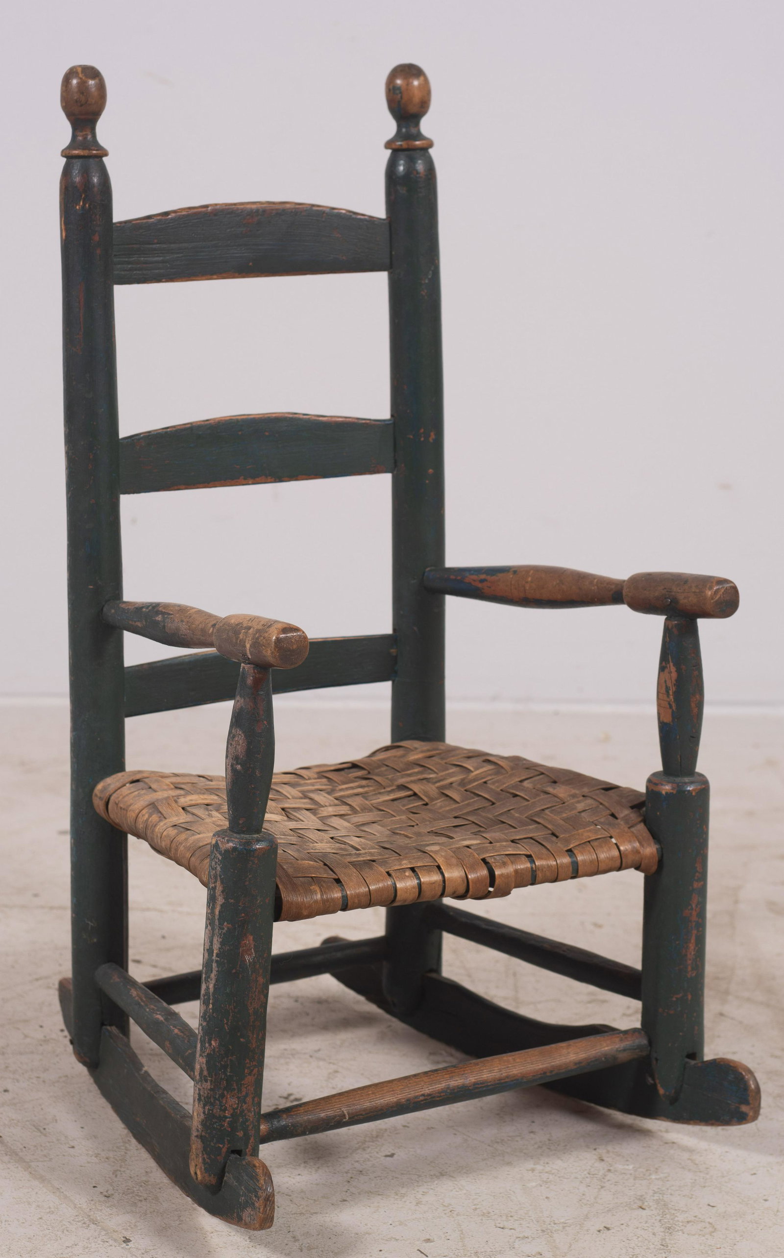 Child's 3 Slat Blue Painted Ladderback Rocker: Child's 3 Slat Blue Painted Ladderback Rocker, woven splint seat, scrubbed wear on arms and finial, pegged construction, 18th c, 27" h, 13" w